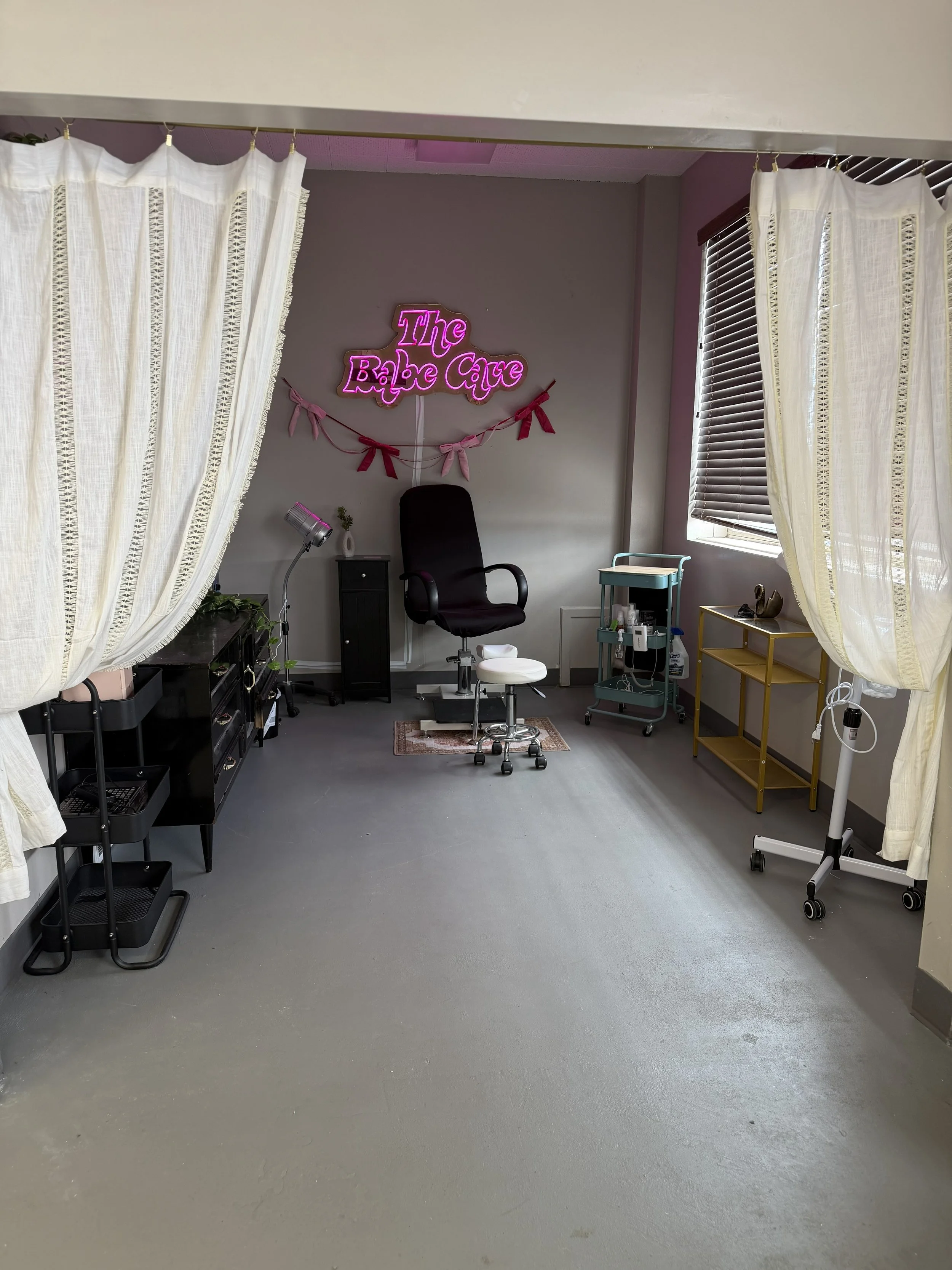 Private beauty studio at Pinché Collective with dry predicure chair, pink neon sign, and natural light.