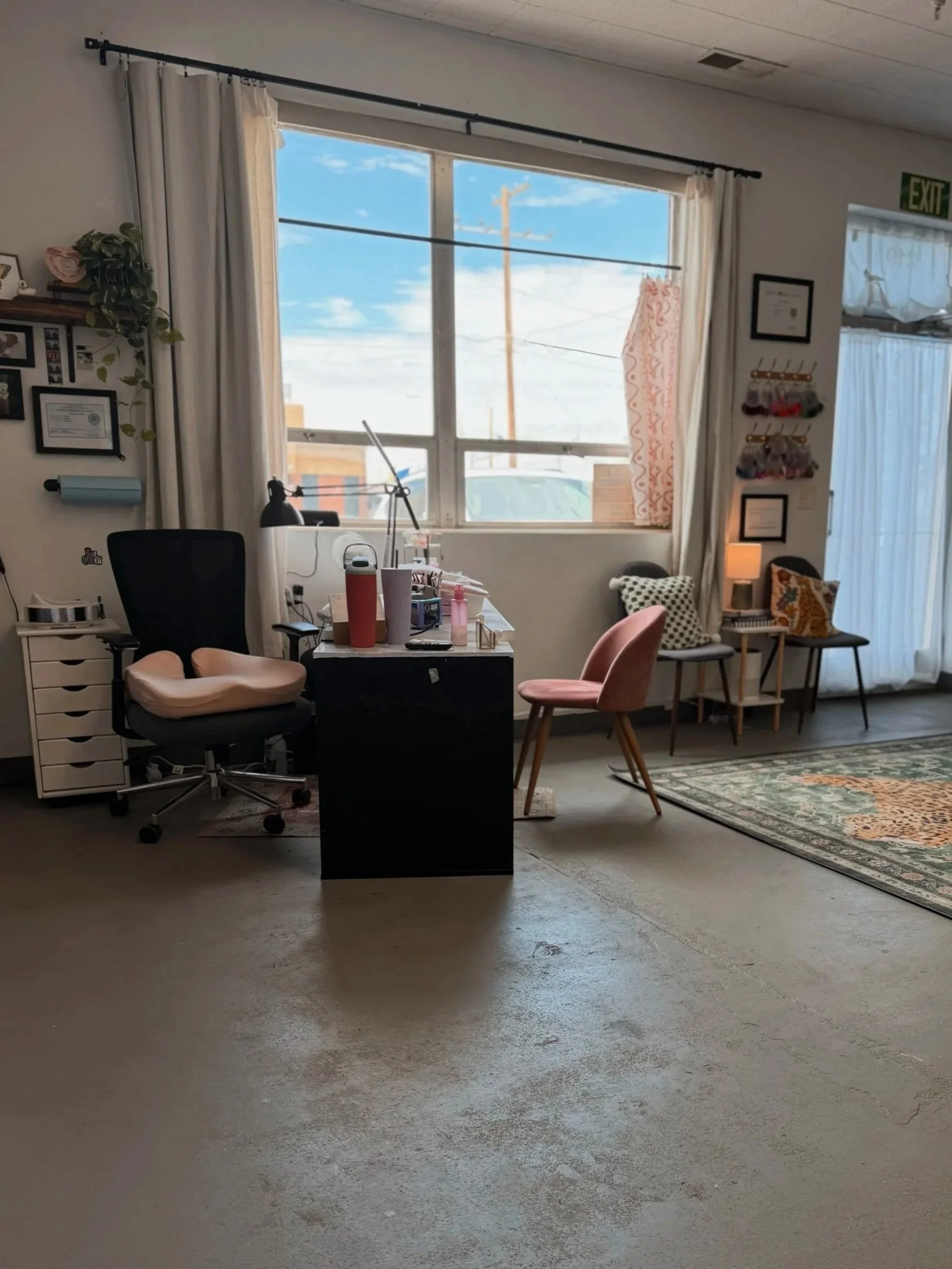 Bright, colorful interior of Pinché Collective nail salon with individual artist stations and large windows.