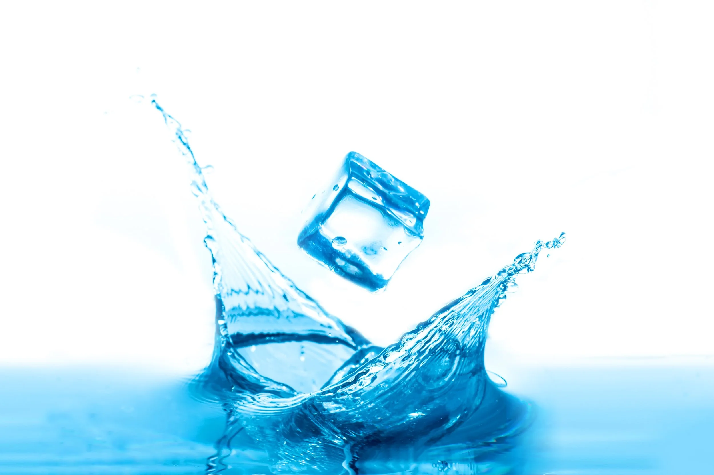 A clear ice cube falling into a splash of water, creating ripples and splashes.