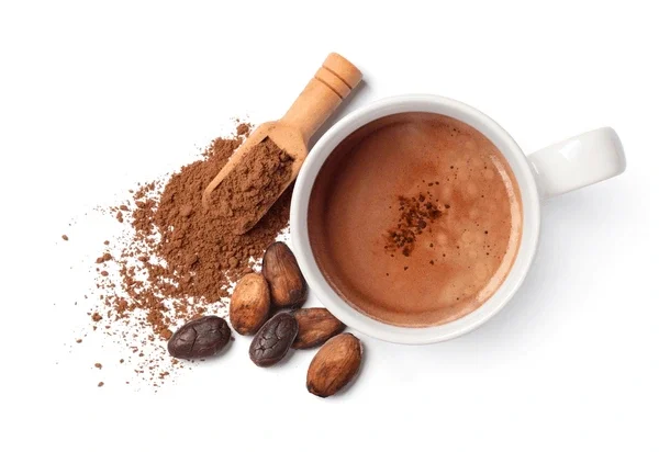 A cup of hot cacao with cocoa powder, a small scoop of cocoa powder, and a few cocoa beans on a white background.