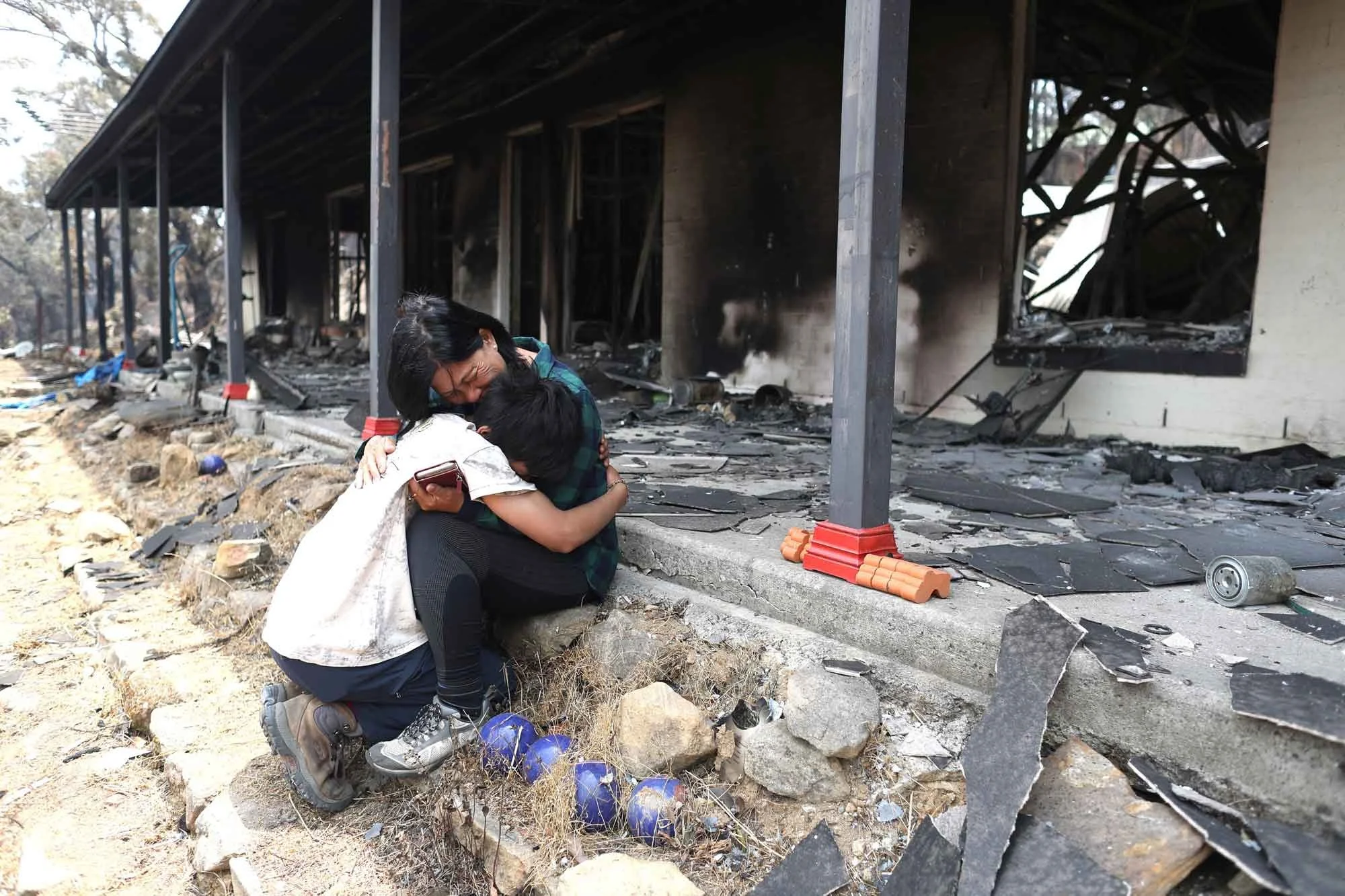  Helena with her son Gabriel on the verandah of their burnt house in station street Balmoral, the Green Wattle Creek fire swept through their village on Saturday afternoon.  Monday 23rd December 2019. Guardian Australia. 