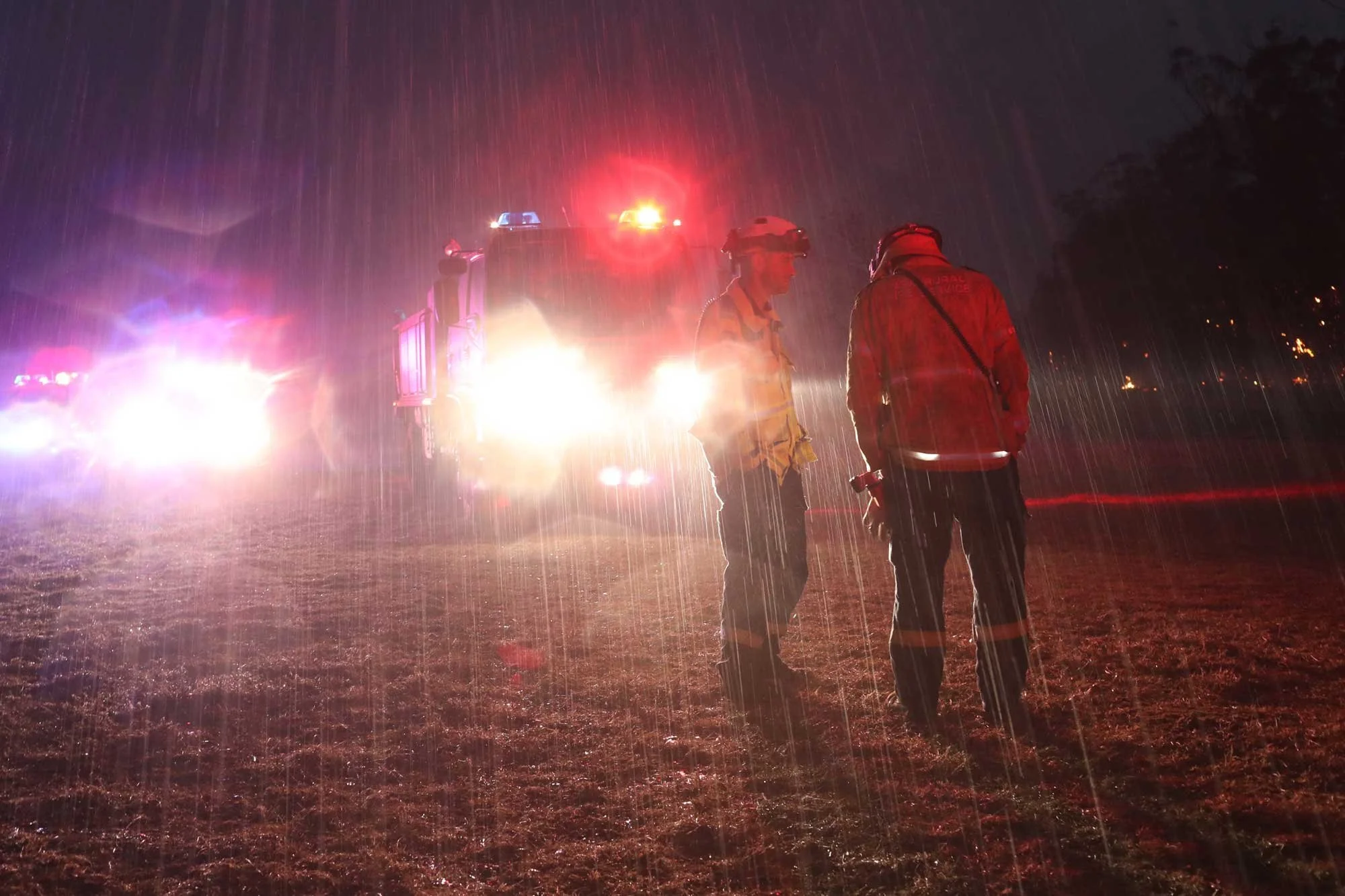  Welcome rains start to fall as RFS crews fight a fire at the Green Wattle Creek fire near Bargo NSW tonight as it starts to rain.   21st December 2019. Guardian Australia. 