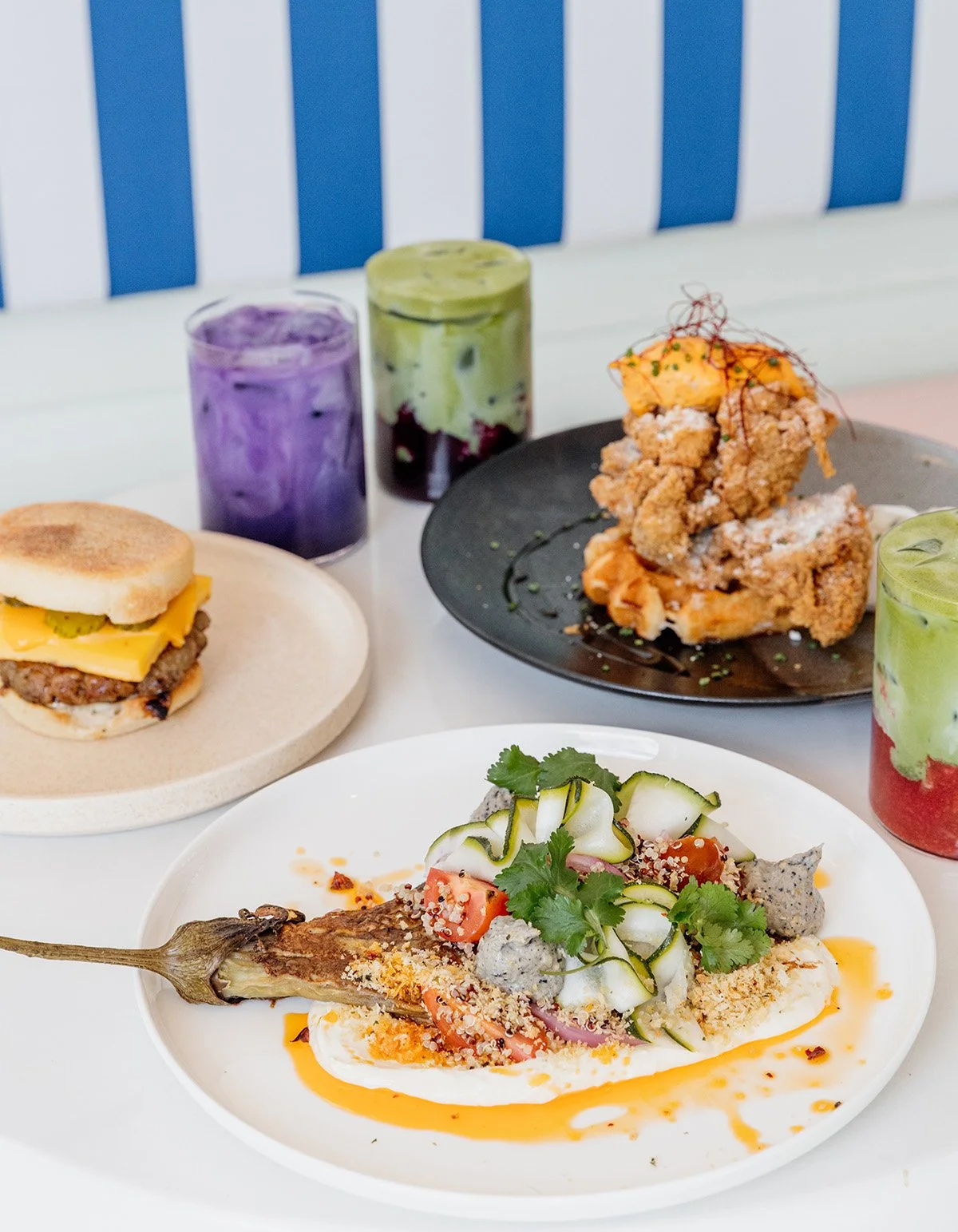 A dining table with a variety of dishes including a fish dish garnished with vegetables and herbs.