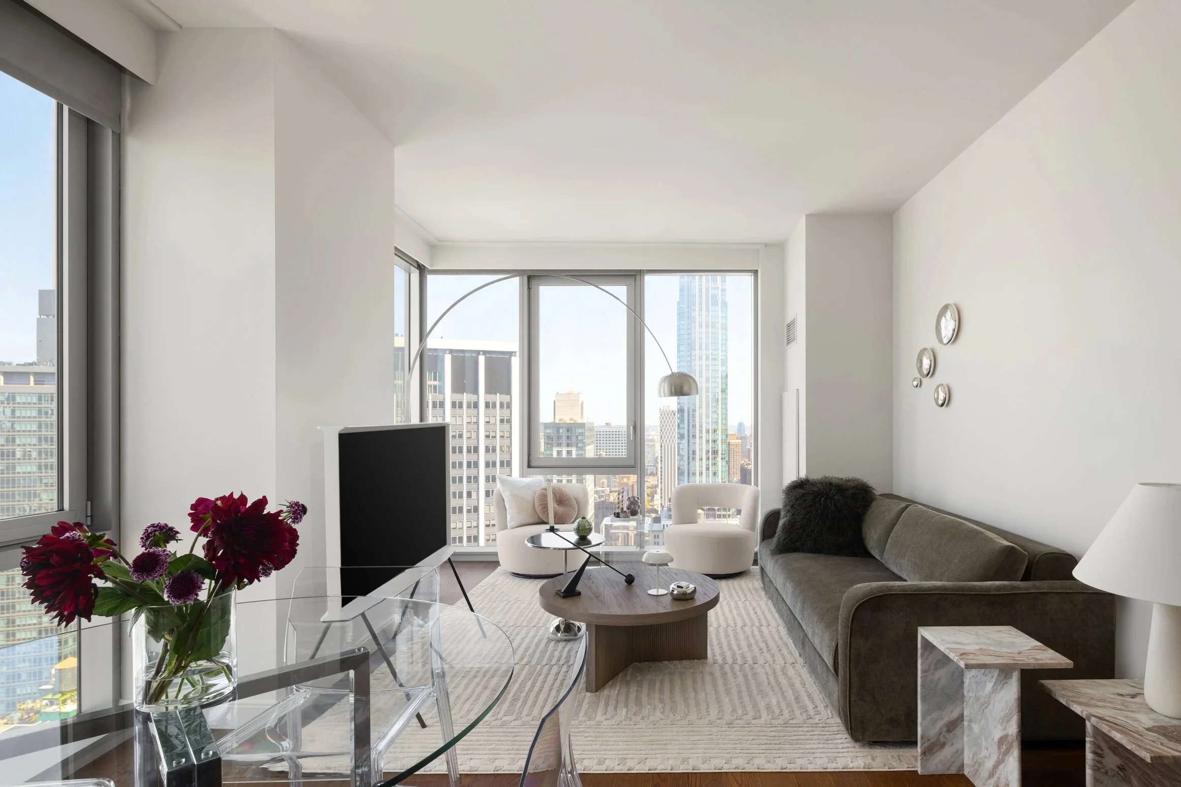 Modern NoMad apartment living room with skyline views, soft neutral furnishings, and contemporary styling designed by Sonia Serrouya