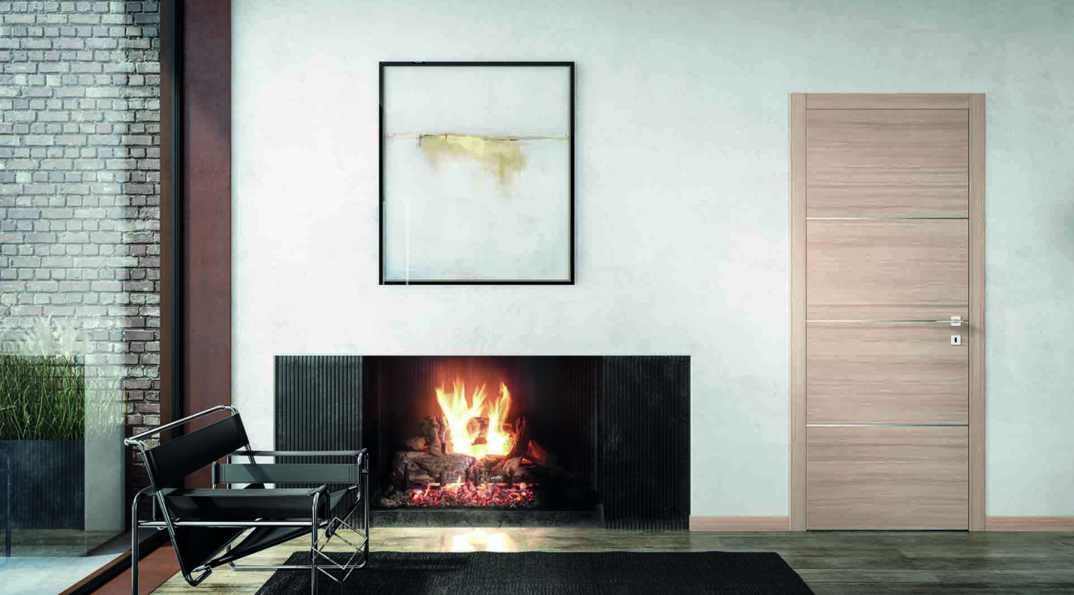 Interno di una stanza con camino acceso, una sedia moderna accanto, una parete di mattoni a vista esterna visibile sul lato sinistro, un quadro astratto appeso sulla parete bianca e una porta di legno chiaro a destra.