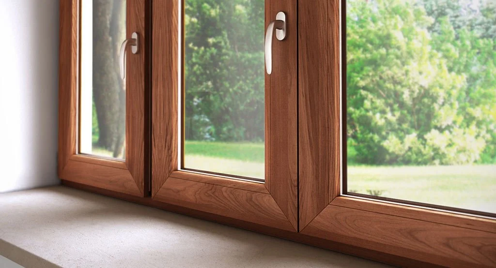Finestra in legno con vetri e maniglia in posizione aperta, vista su un giardino verde con alberi.