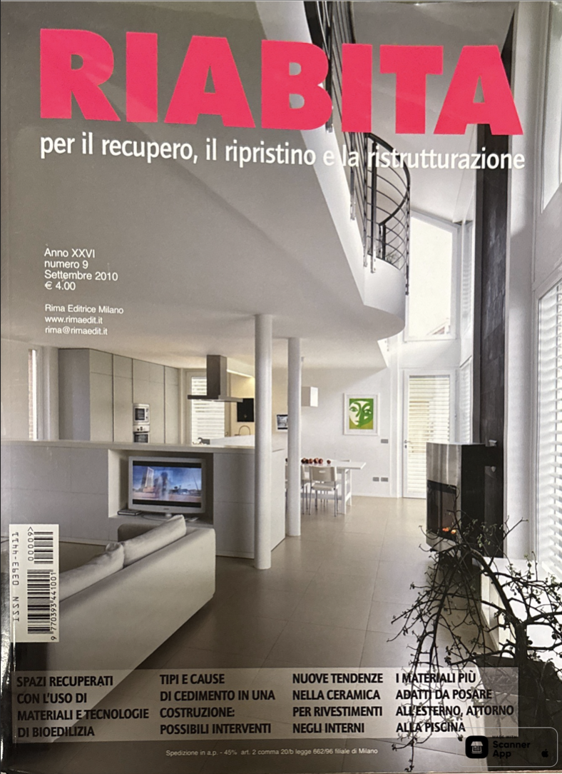 Copertina di una rivista intitolata 'RIABITA' che tratta di recupero, restauro e ristrutturazione, mostra un interno moderno di casa con camino, televisore e zona pranzo luminosa.