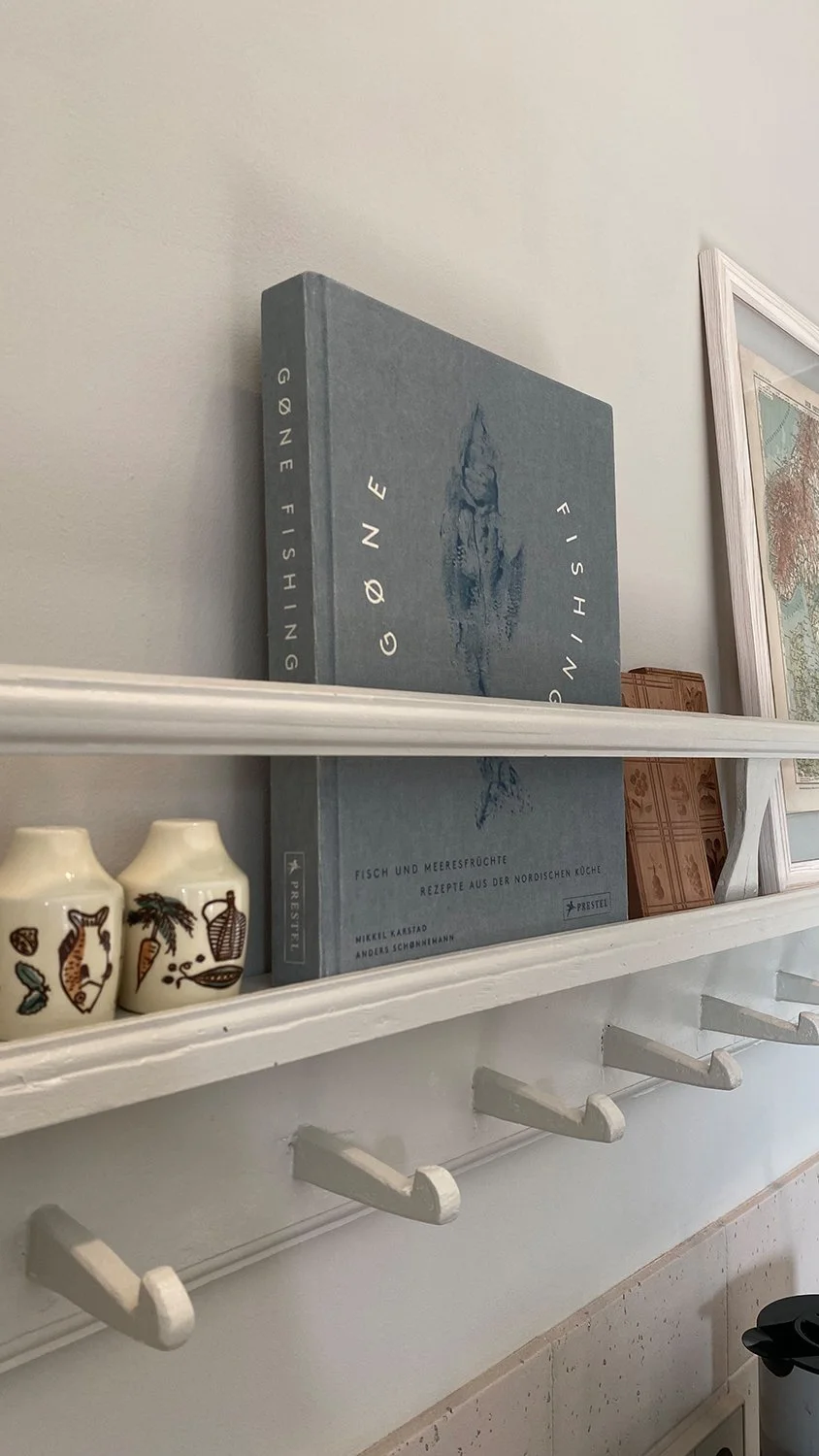 Detail Tellerboard im puristischen Stil in der Küche mit Fisch-Kochbuch 