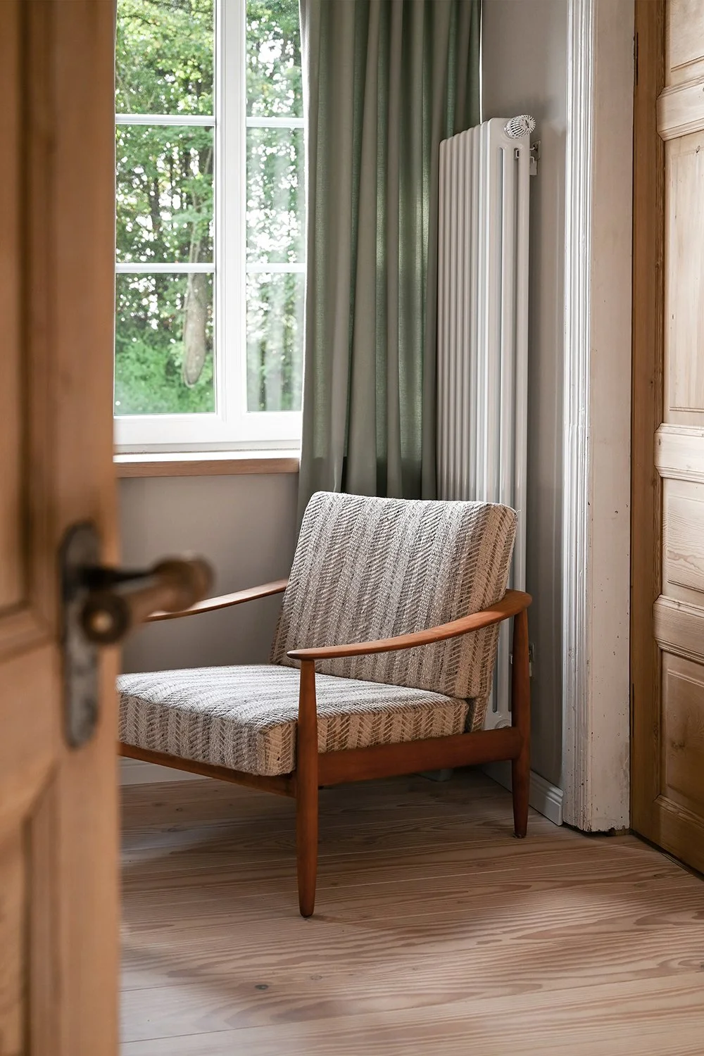 Sessel im Schlafzimmer des Ferienhauses mit Blick in den Garten