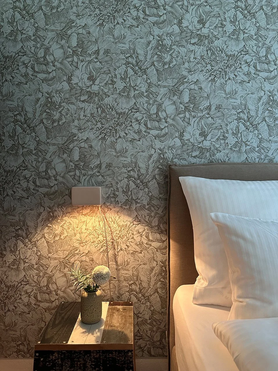 Nachttisch am Boxspringbett vor Design-Tapete