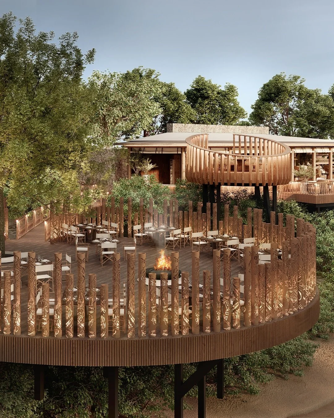 A multi-level wooden restaurant or lounge built among trees with a circular deck, tables and chairs, a fire pit, and a decorative wooden railing.