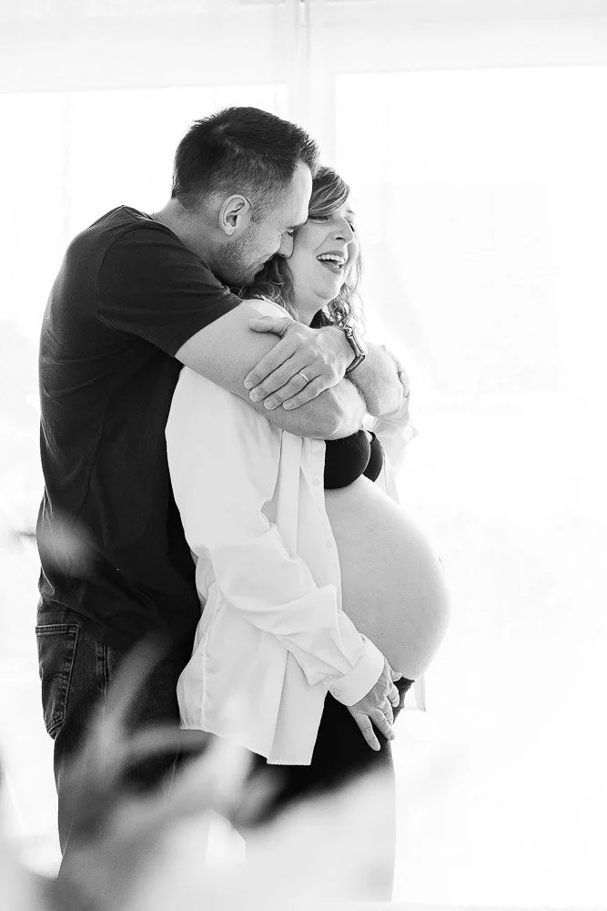 Un couple heureux avec une femme enceinte, lui donnant un câlin. Reportage photo grossesse intimiste côte d’opale, Dunkerque, Calais, Wissant, Wimereux, Boulogne-sur-Mer, Hardelot-plage, Le Touquet, Lille, sangatte