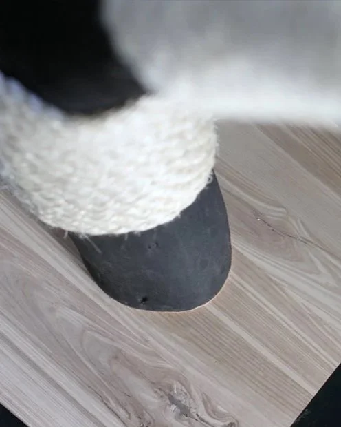 Close-up of natural sisal rope wrapped around a black wooden scratching surface