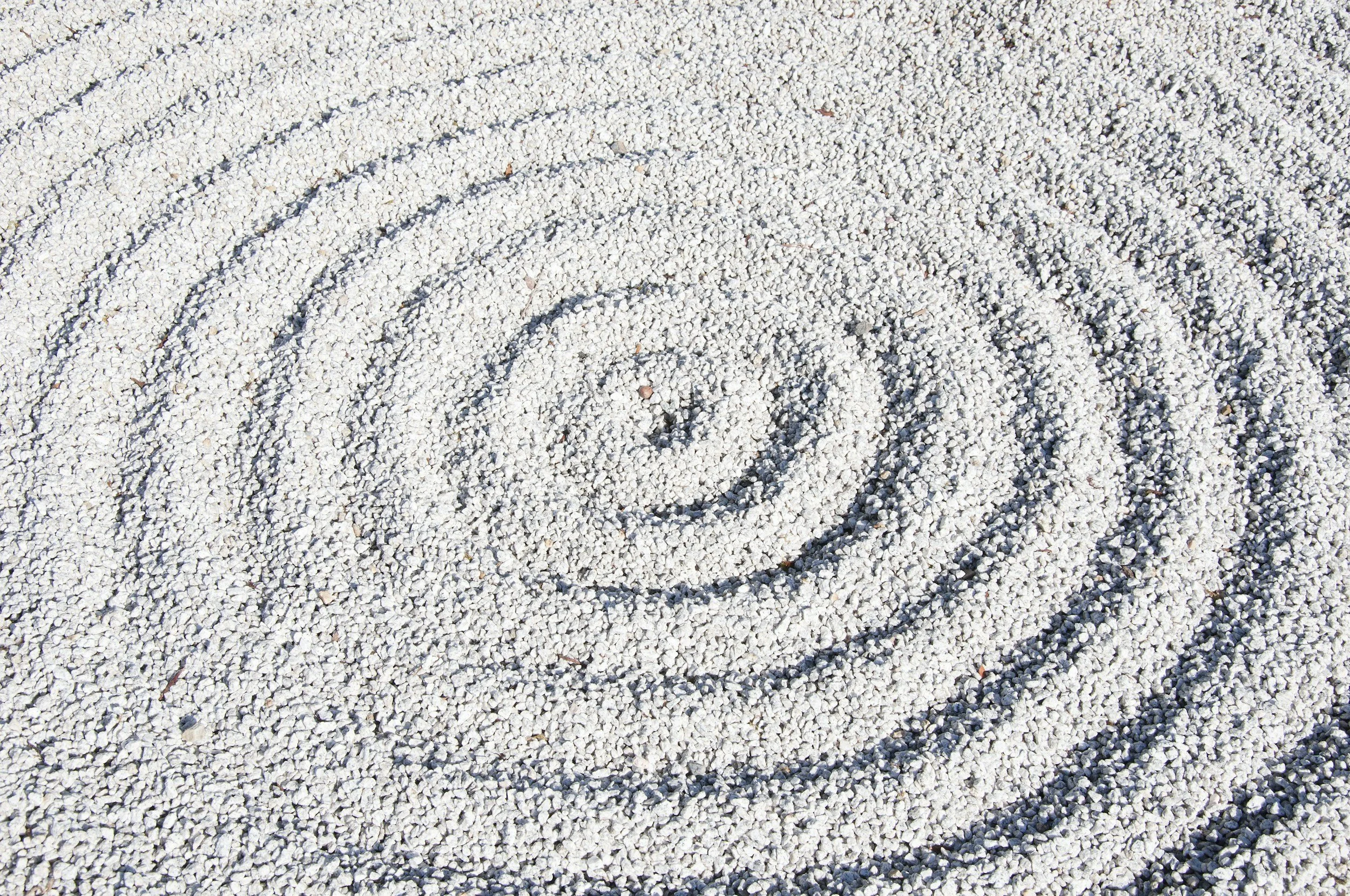 a spiral in the sand representing the waves of healing