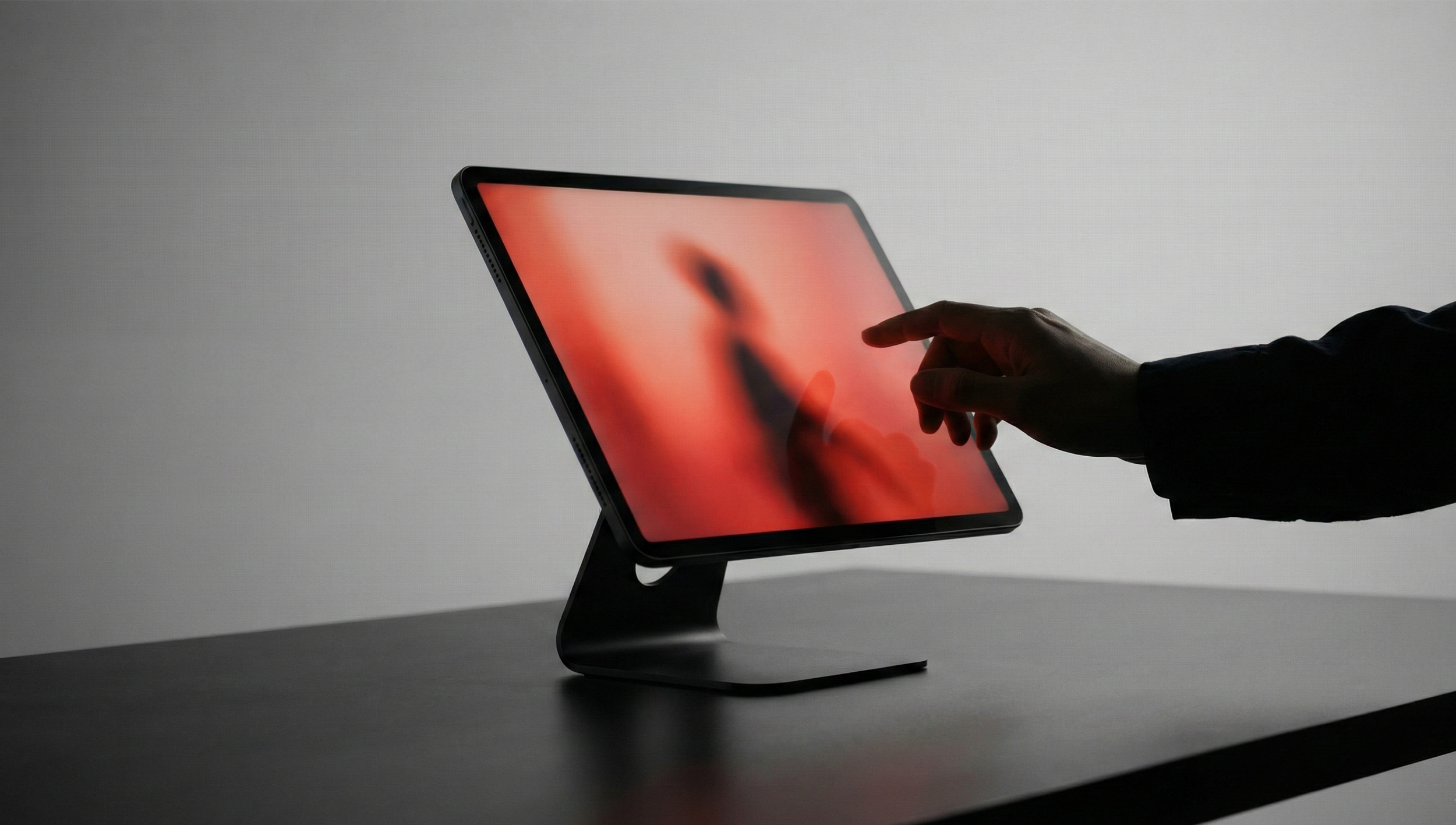 A silver laptop on a plain gray surface displaying a website for a restaurant or cafe, with overlapping pages showing images of food, interior decor, and text describing the business's philosophy, menu, and gallery.