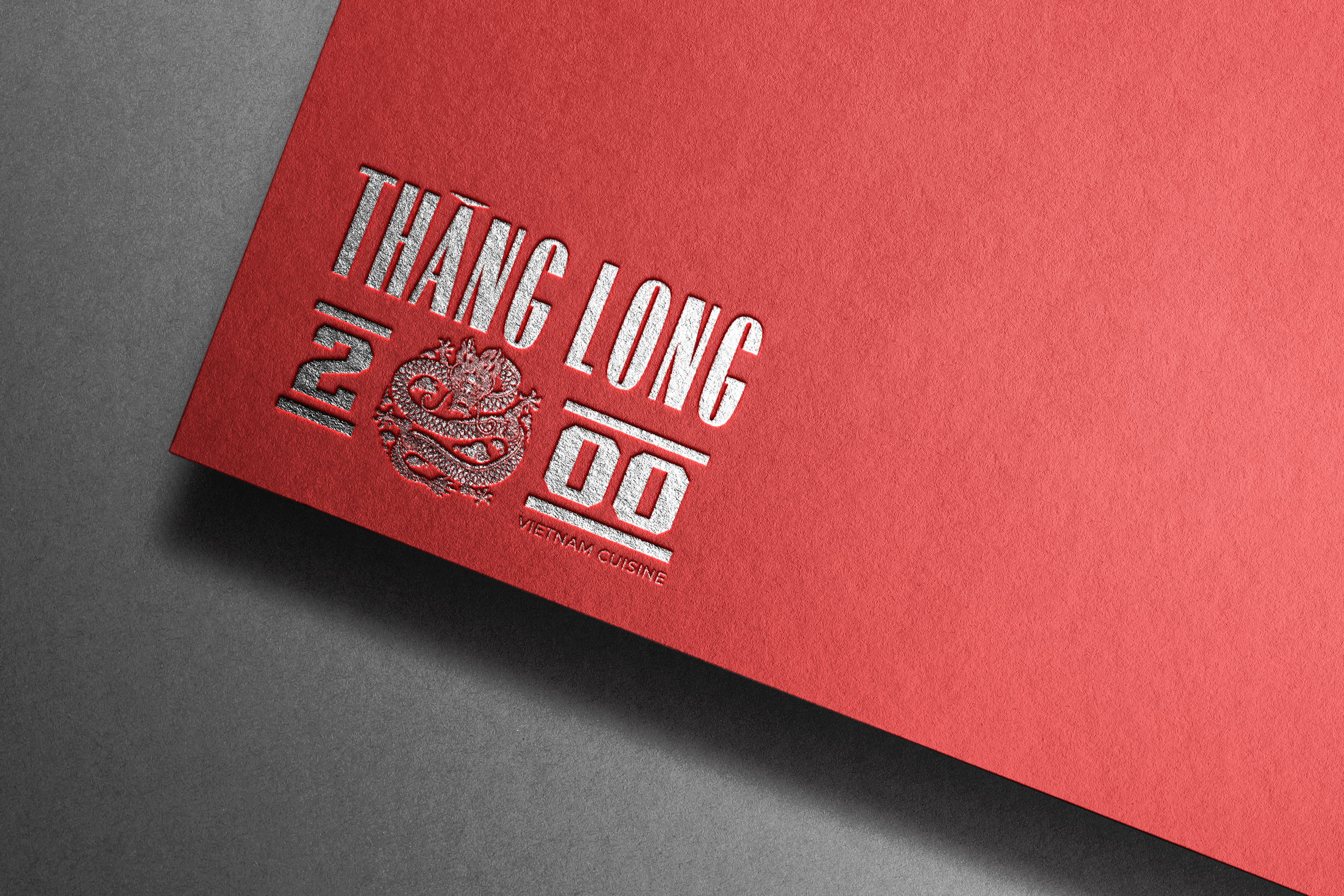 Red textured menu or card with embossed silver text reading 'Thank Long Do 2012' with a decorative dragon illustration and 'Vietnam Cuisine' underneath.