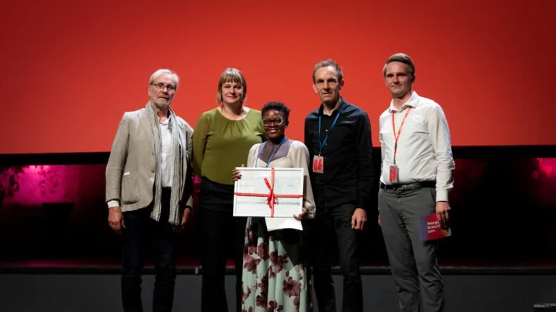   Award winner Patience Nitumwesiga in the foreground with the ver.di jury consisting of Rüdiger Steinmetz, Julia Cruschwitz and Rüdiger Trojok, as well as union secretary Lucas Munzke (from left to right). Photo: Sophie Mahler/DOK  