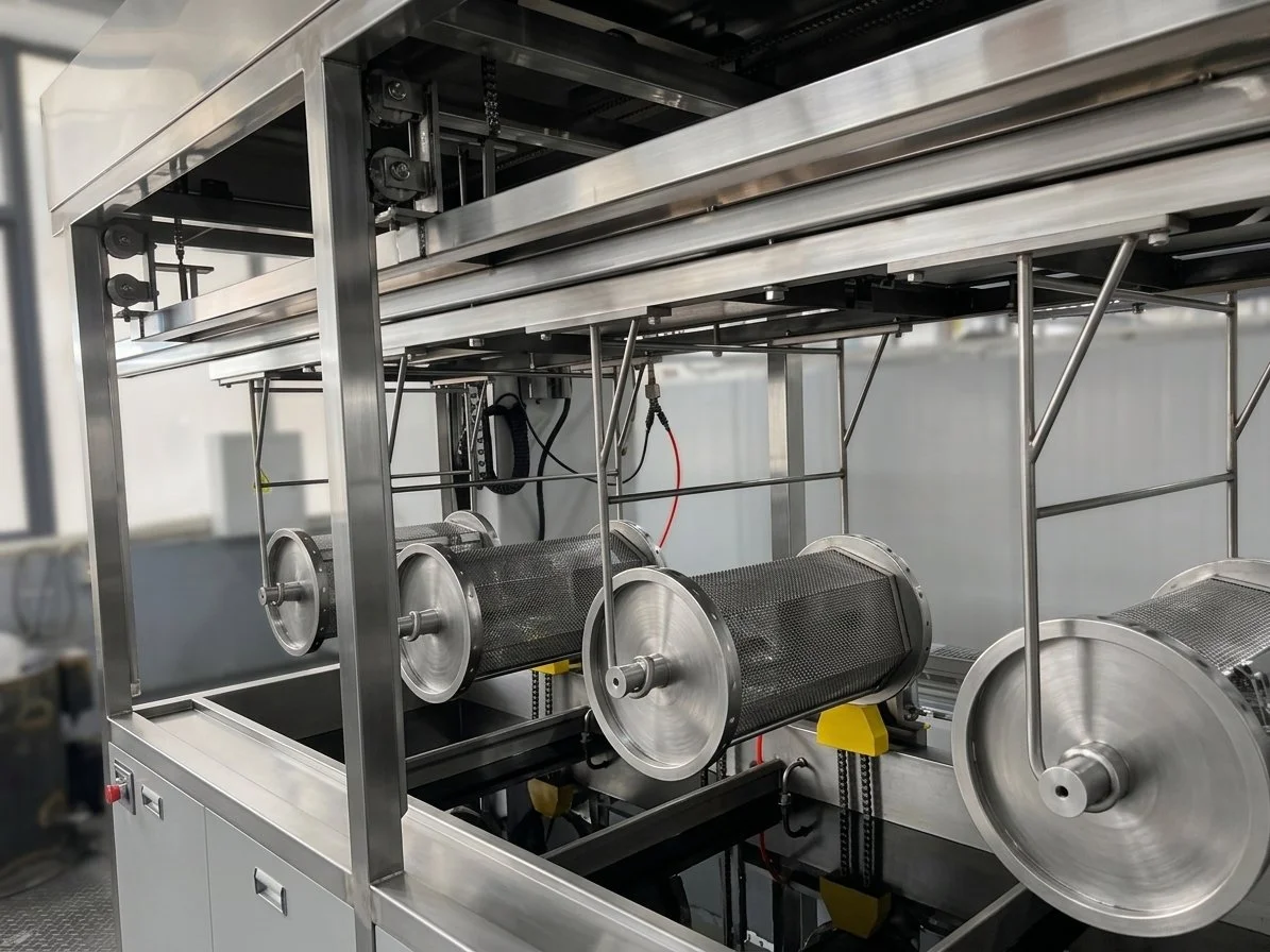 Stainless steel industrial machine with rotating drums to clean parts