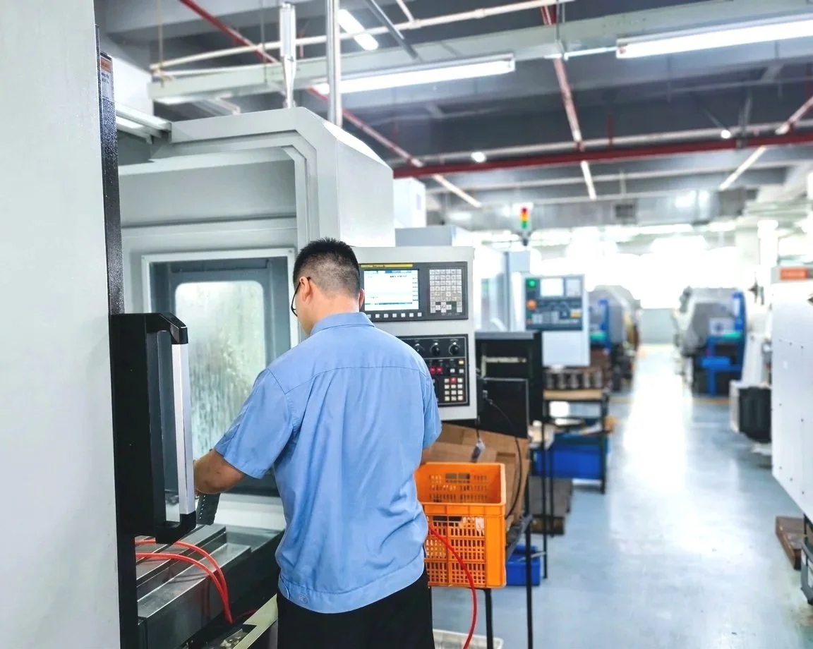 Technical engineer adjusting the cnc machine on the factory floor