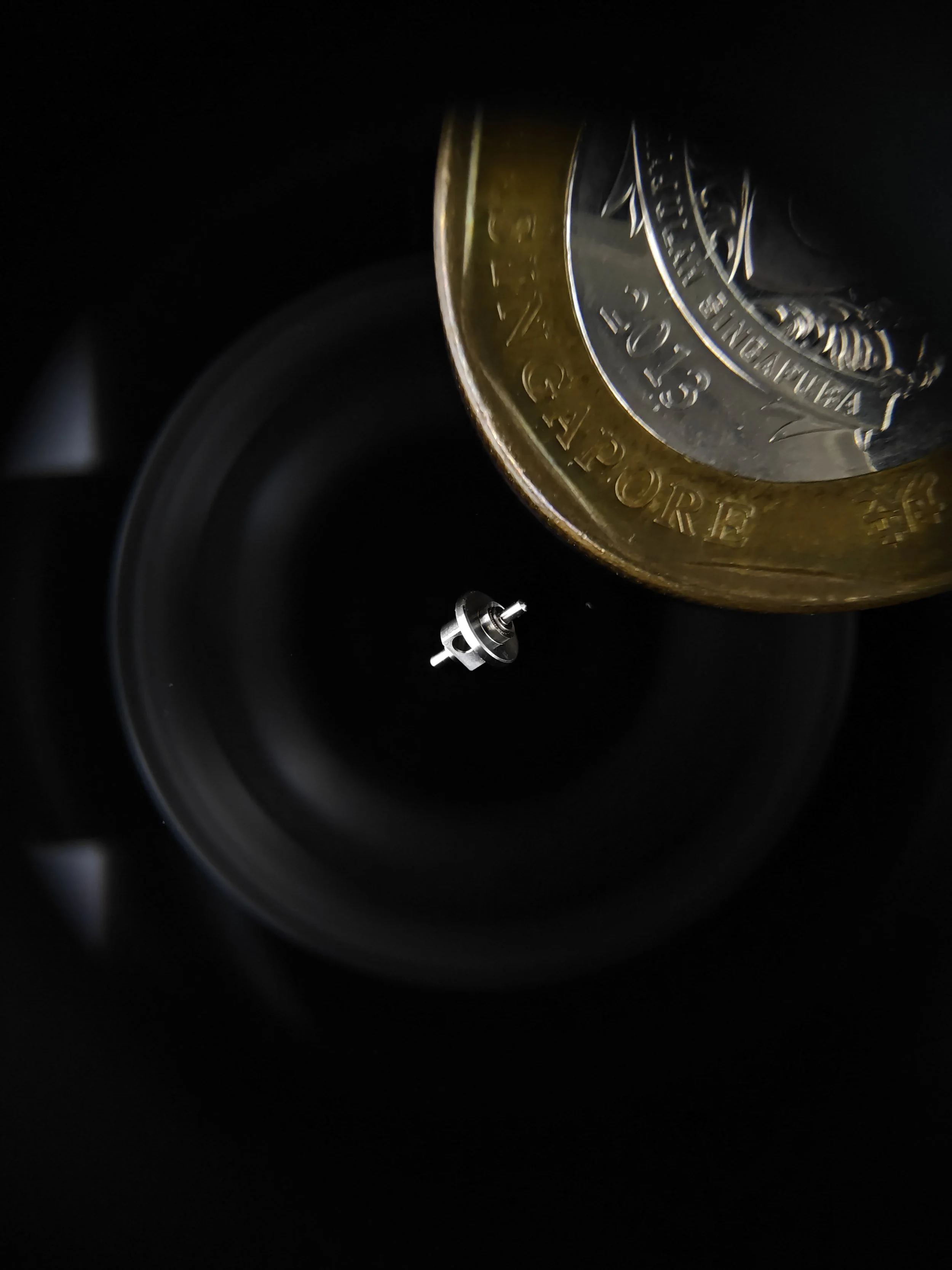 Close-up of a highly precise part with tight tolerances with a Singapore dollar