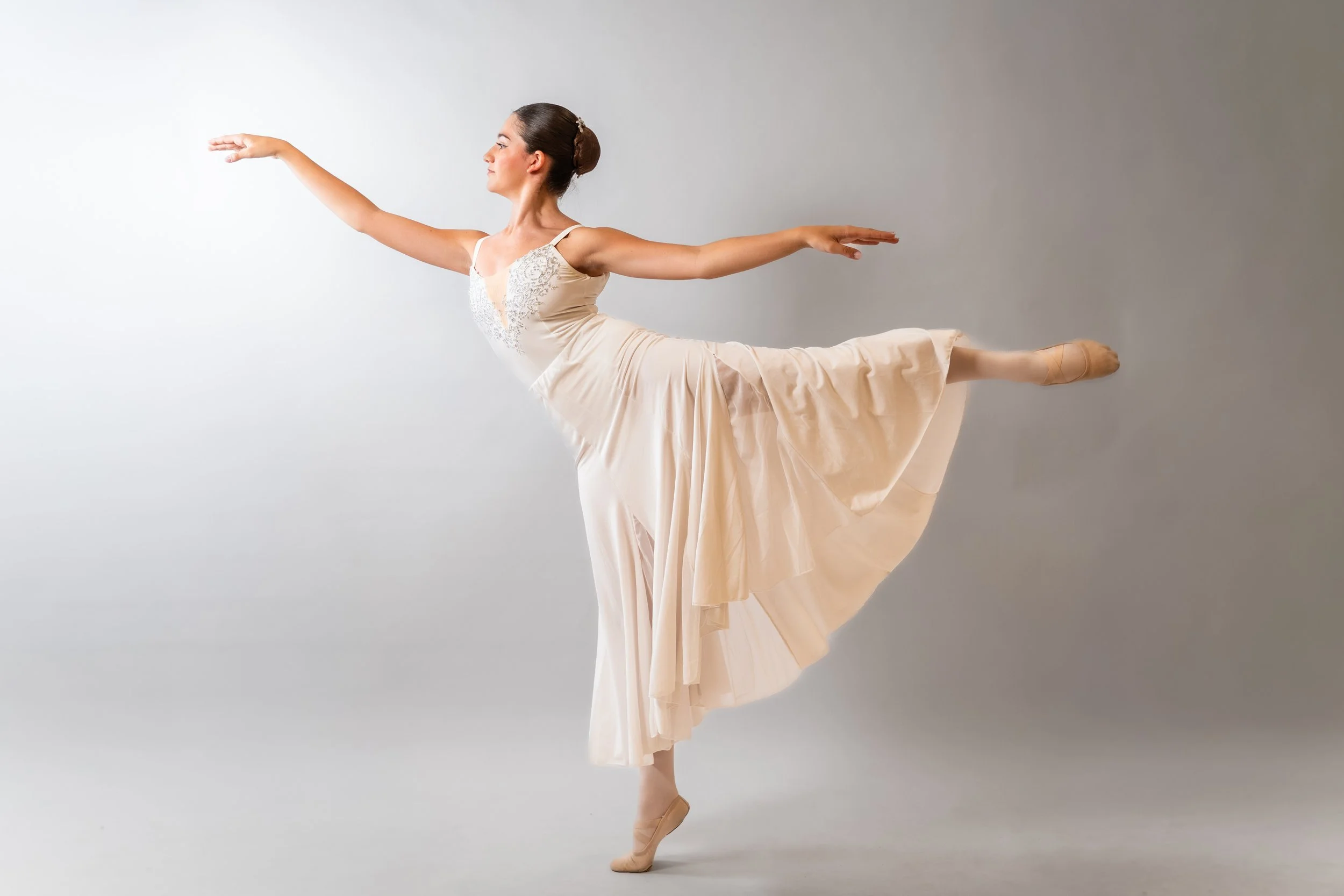 Due persone sono coinvolte in un'arte performativa, una in piedi a testa in giù e l'altra che sostiene con una corda, in un ambiente scuro.