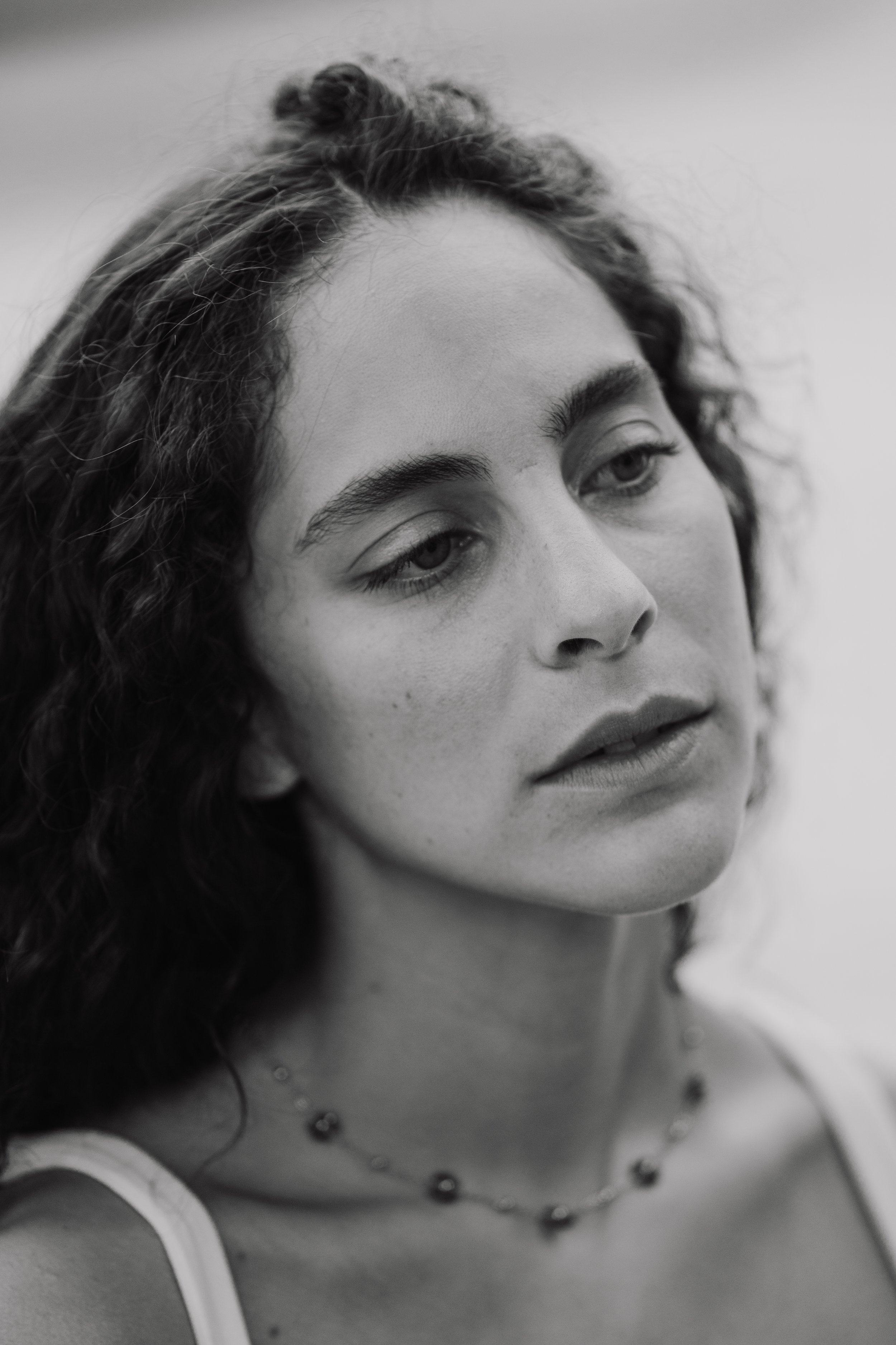 Ritratto di una donna con capelli ricci e occhi chiusi, in bianco e nero, con un'interpretazione artistica e contemplativa.