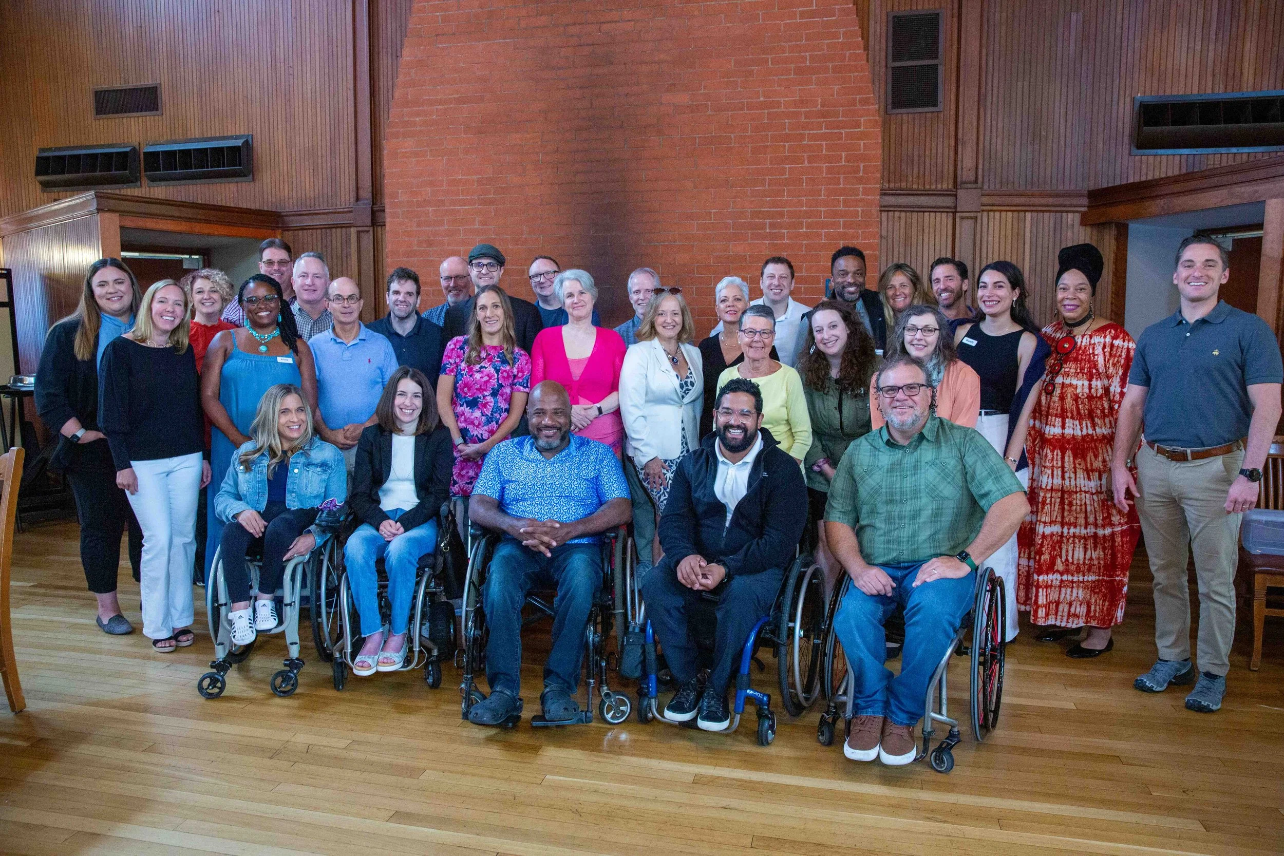 Group posing and smiling with a fireplace behind them