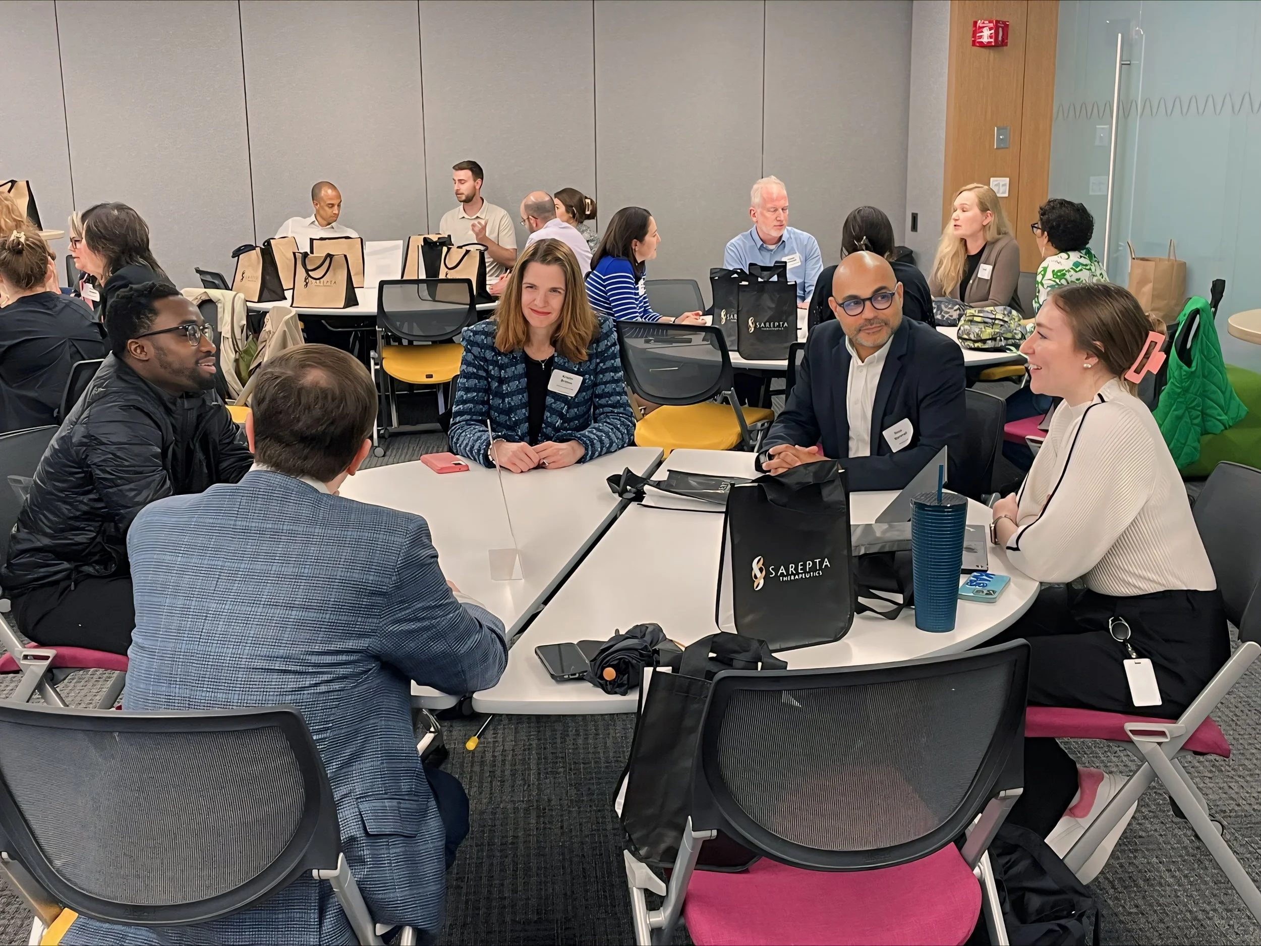 Group of individuals networking at a table in a corporate office setting