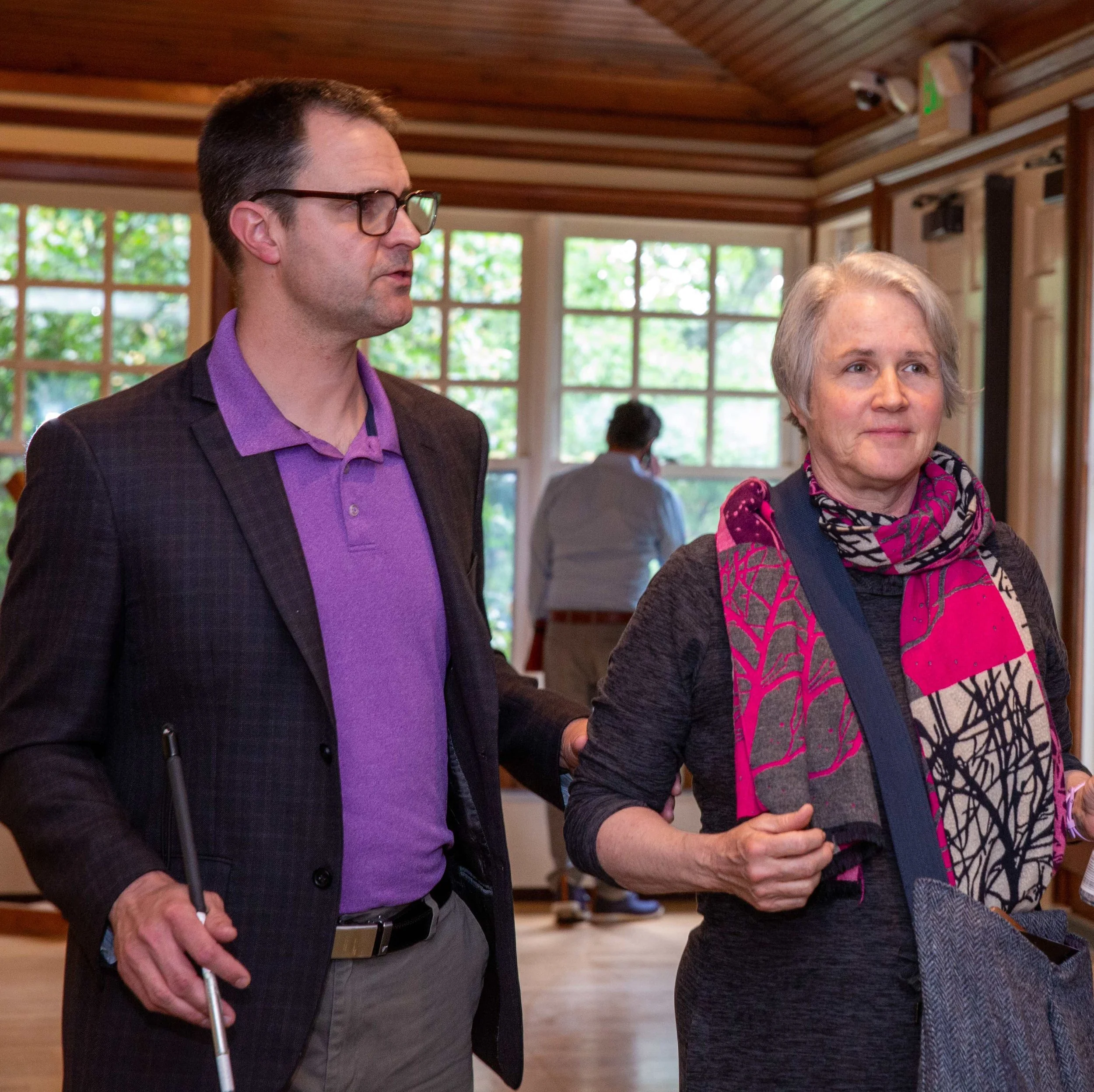 Man grasping the elbow of a colleague while walking