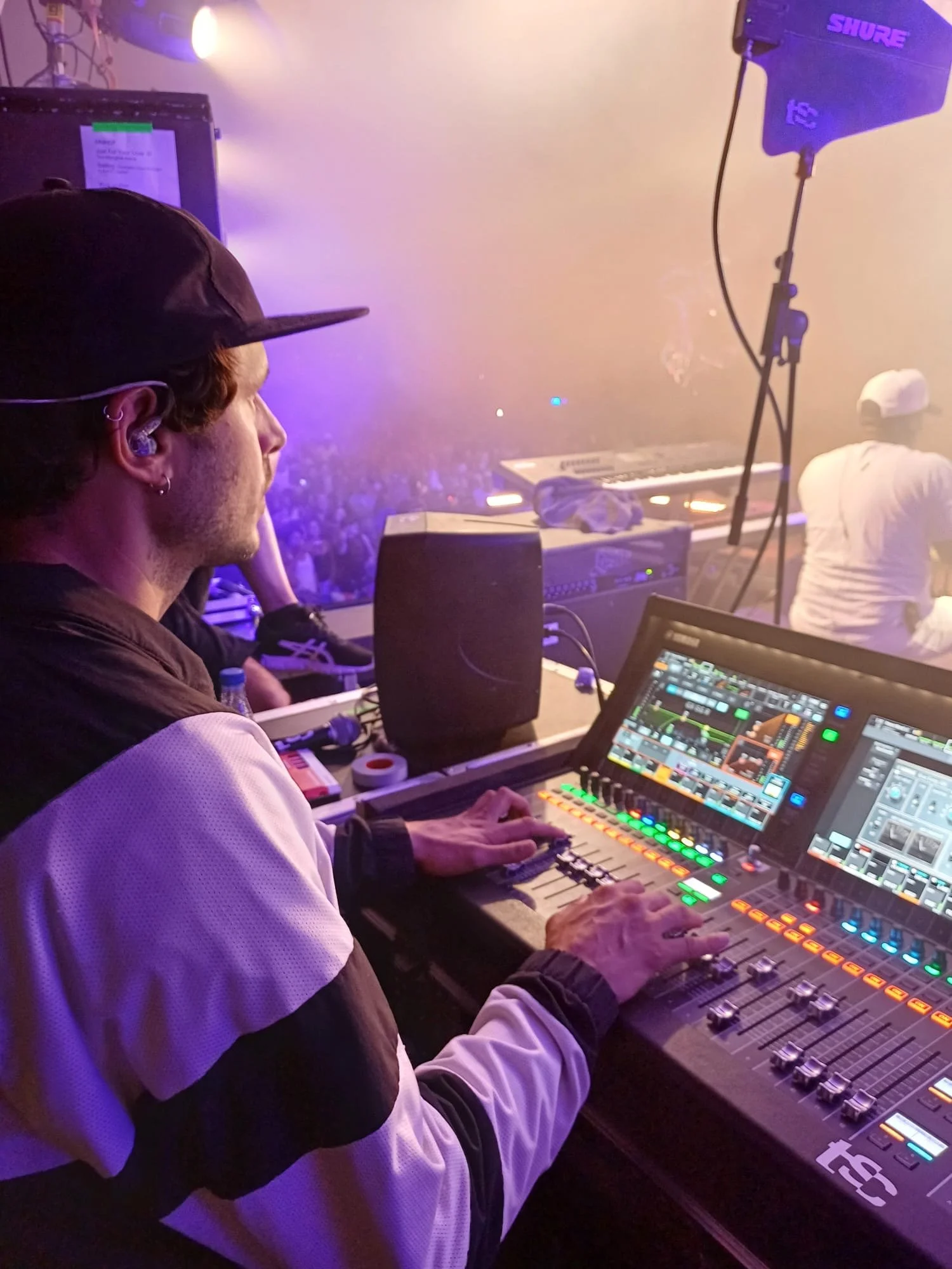 Consola Yamaha DM7 utilizada para mezcla en directo durante concierto con escenario y público