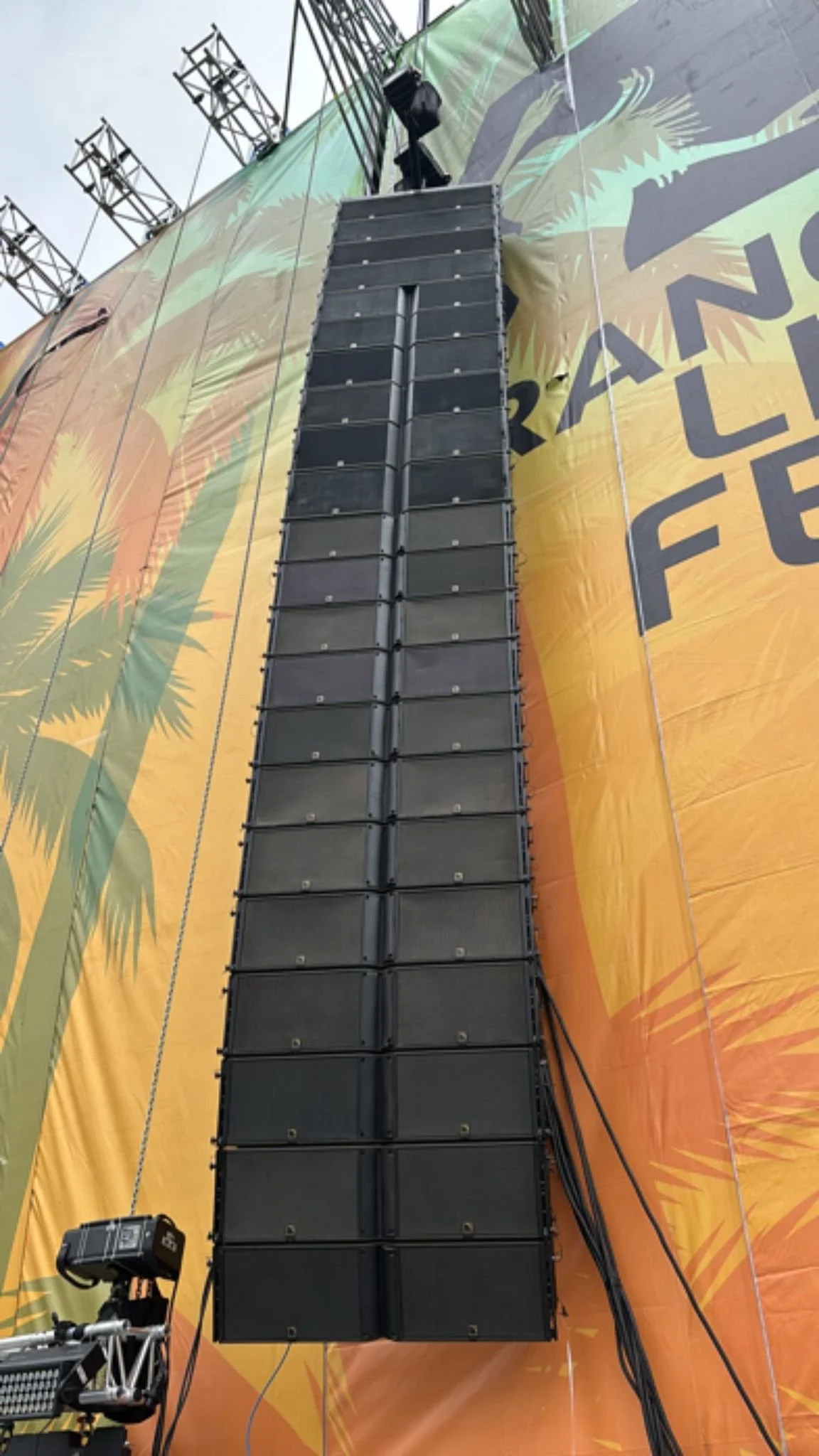 Sistema line array instalado para refuerzo sonoro en escenario principal de festival