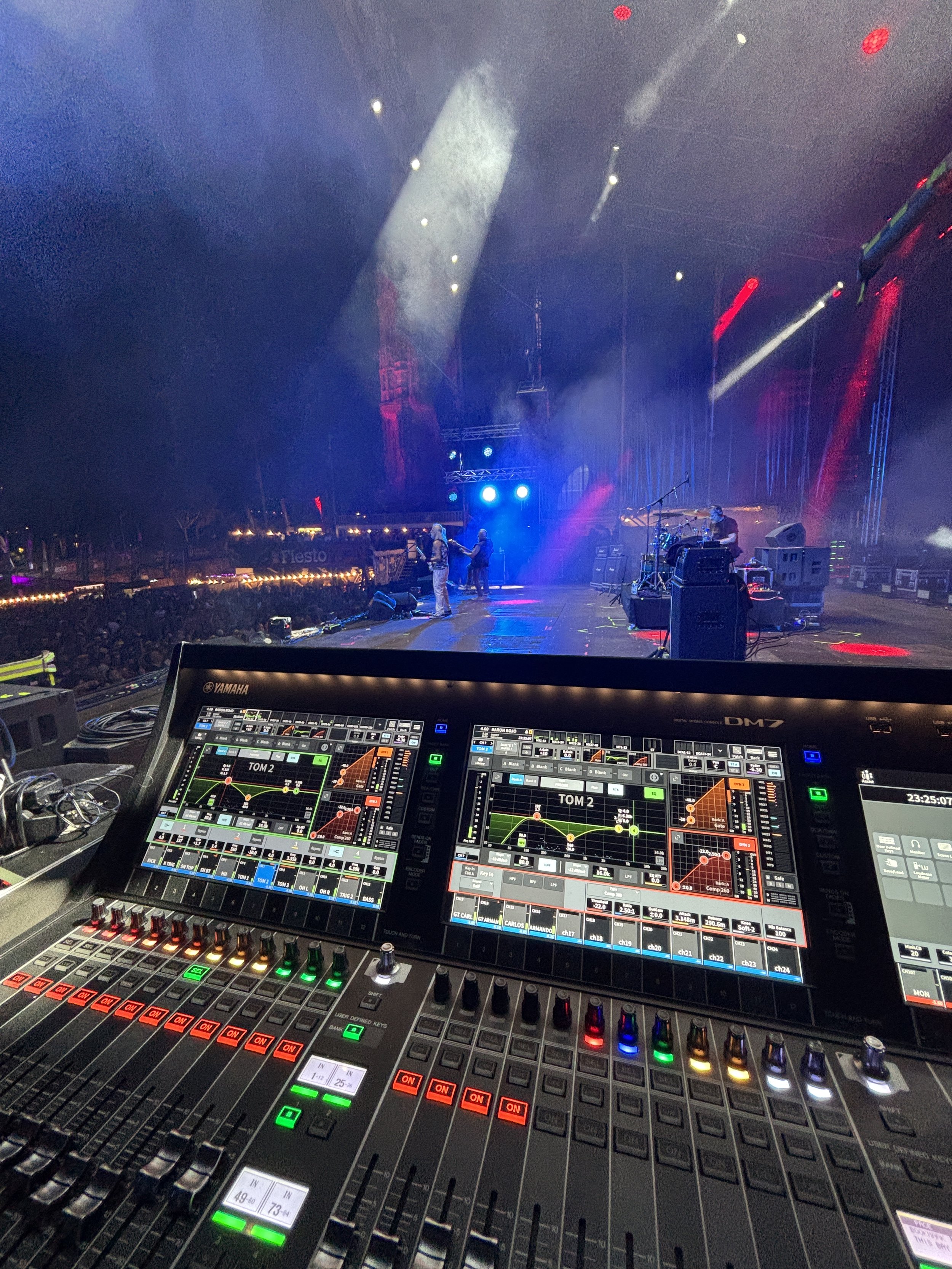 Consola de mezcla de monitores preparada para producción de sonido en escenario de festival