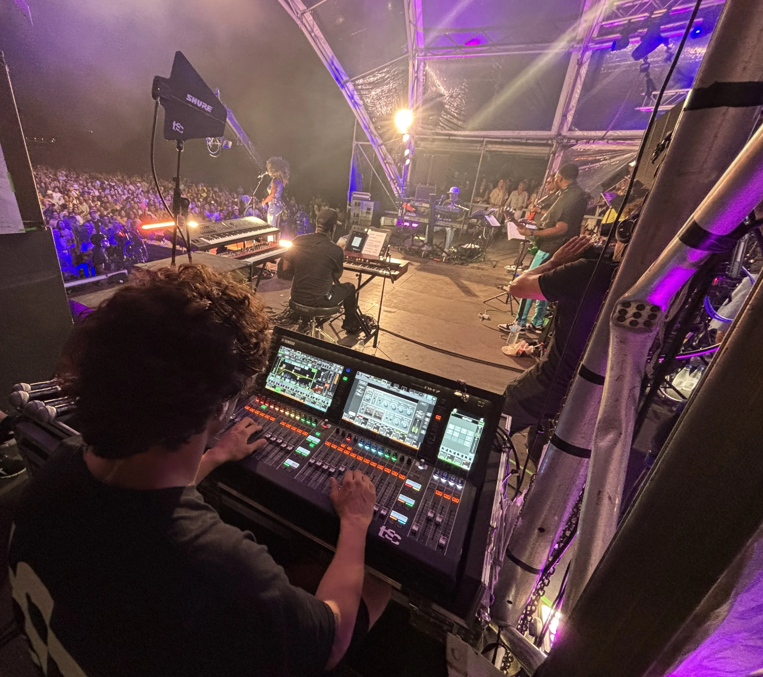 Técnico de monitores operando mezcla de escenario durante concierto en directo con banda