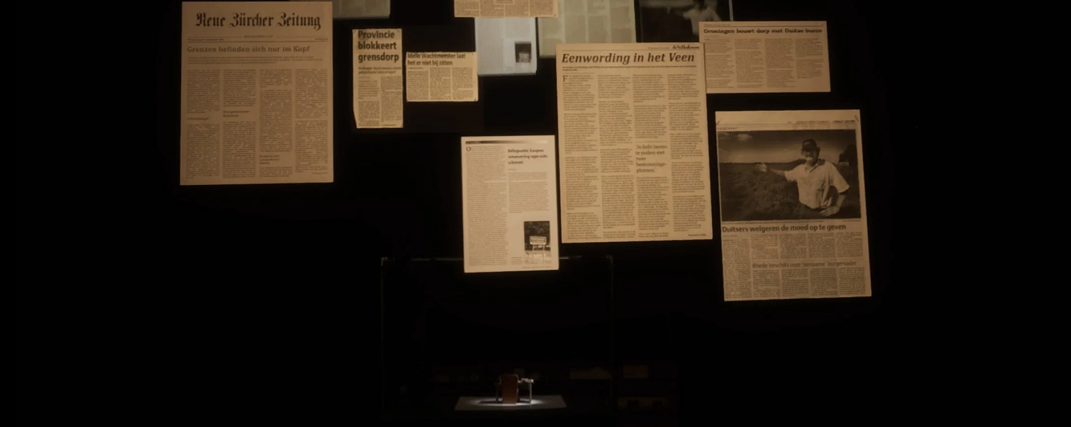 Newspaper clippings float in augmented reality above a miniature desk.