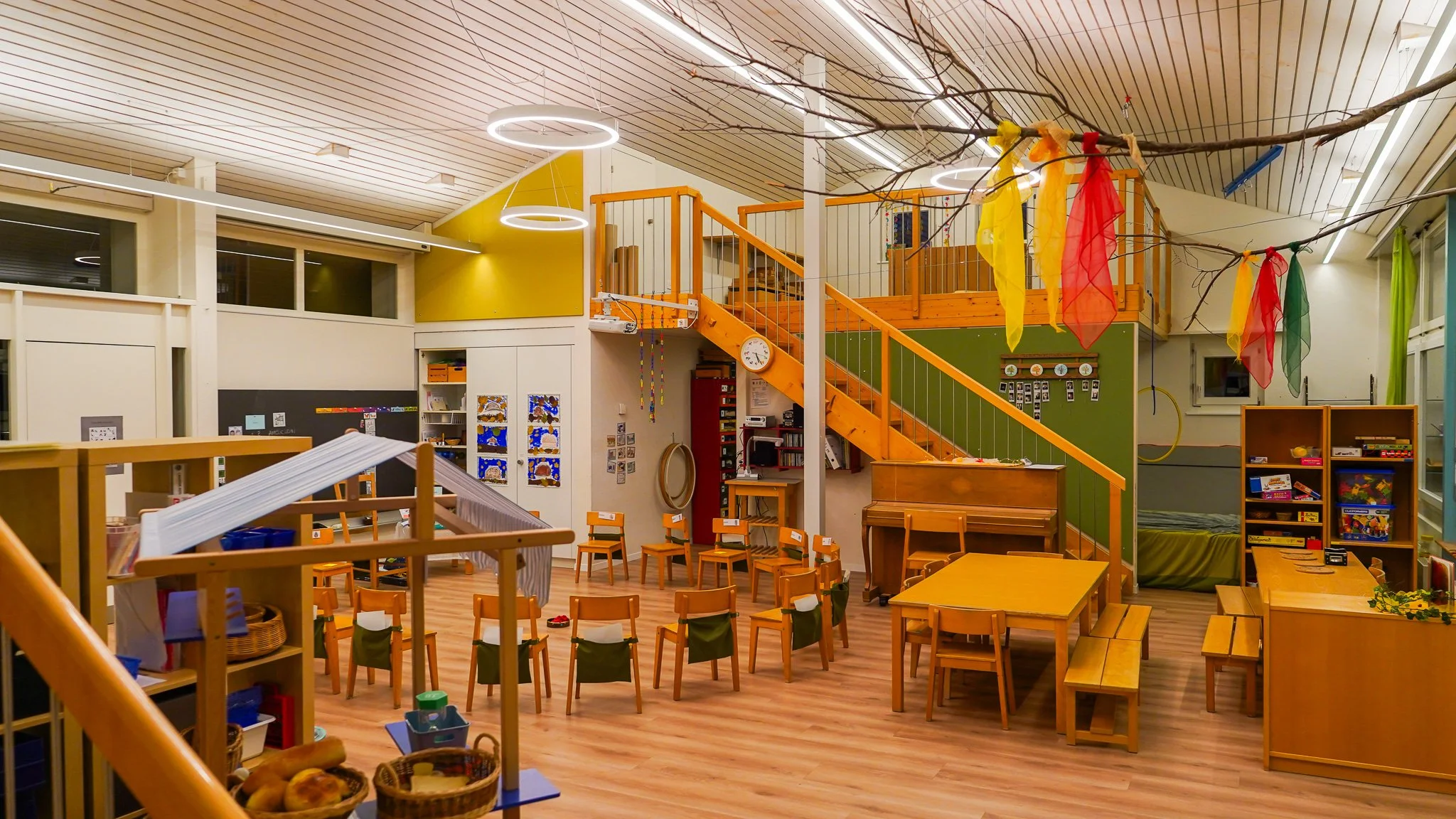 Kindergarten mit direkter und indirekter Beleuchtung aus Ring- und Linearleuchten, Holzboden und weisser Holzdecke - Lichtdesign studio ombré Schweiz