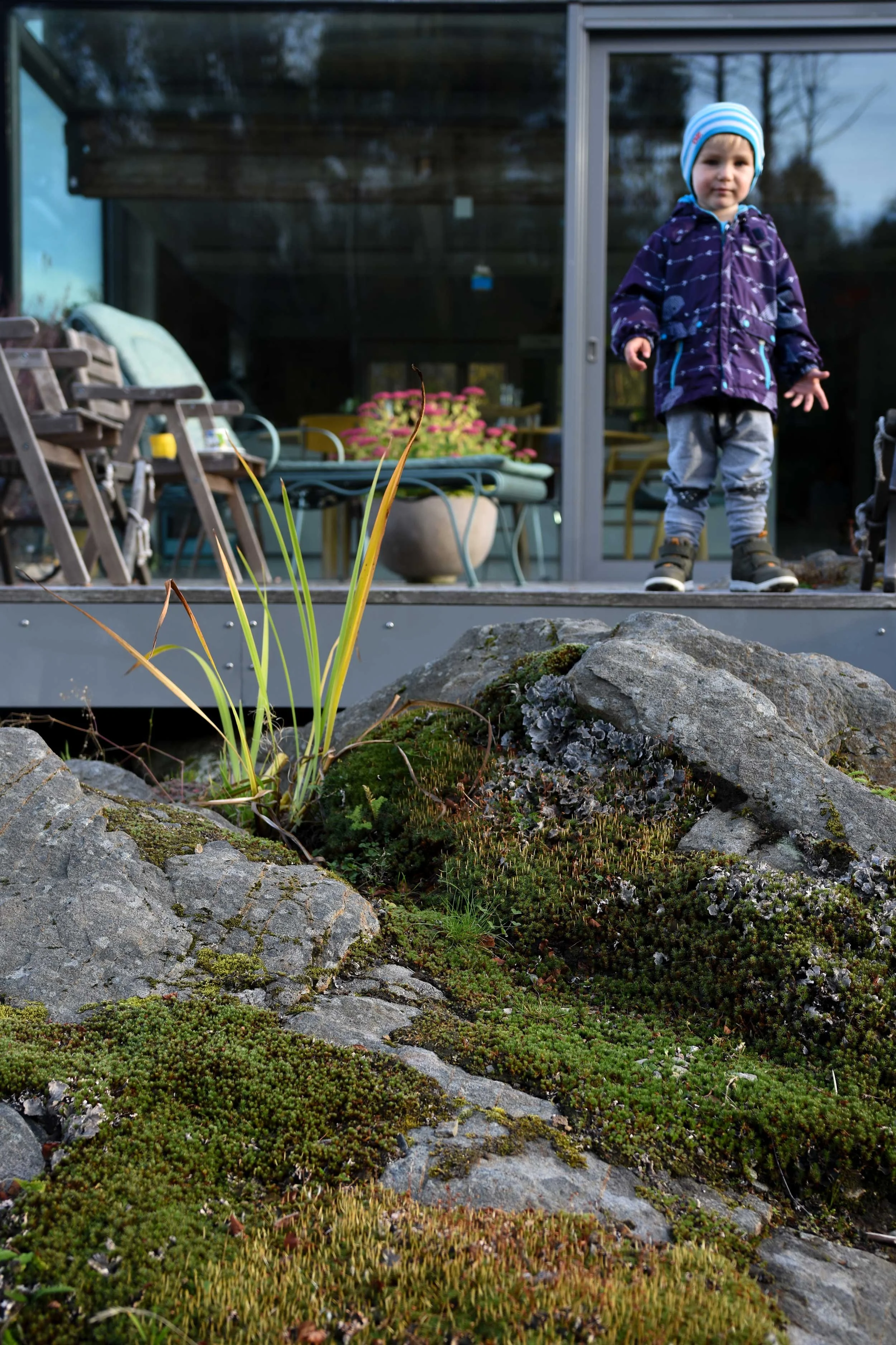 Møte mellom moderne arkitektur og naturen i form av berg og mose.