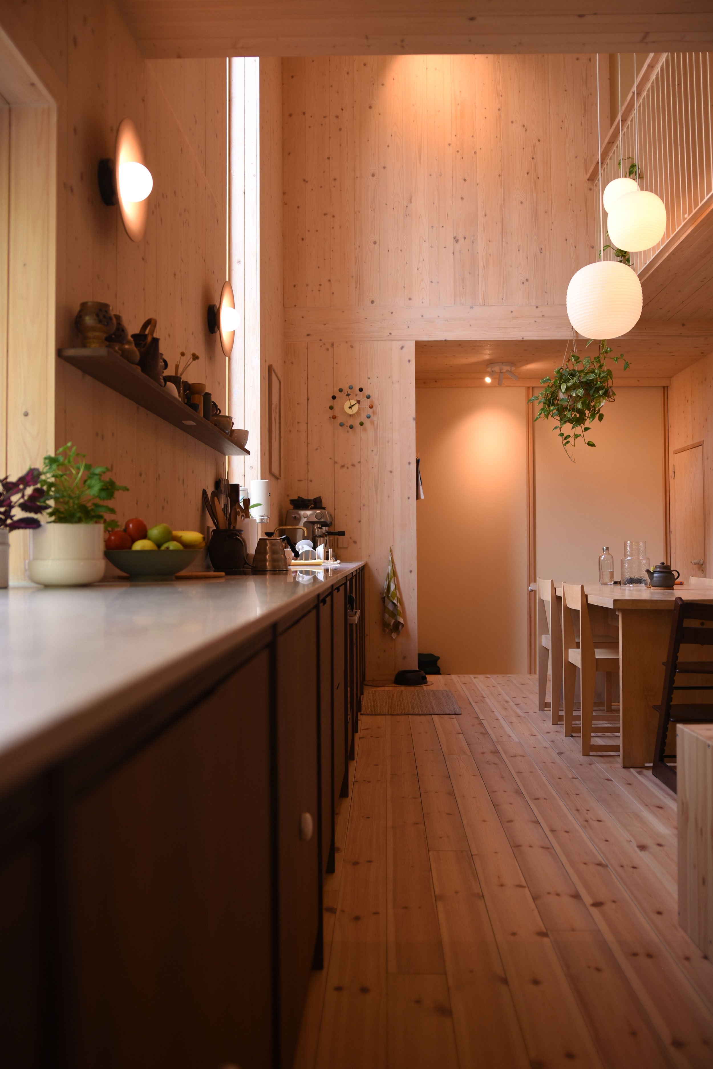 Steinkjøkkenbenk med høyt vindu og innvendig atrium av massivtre.