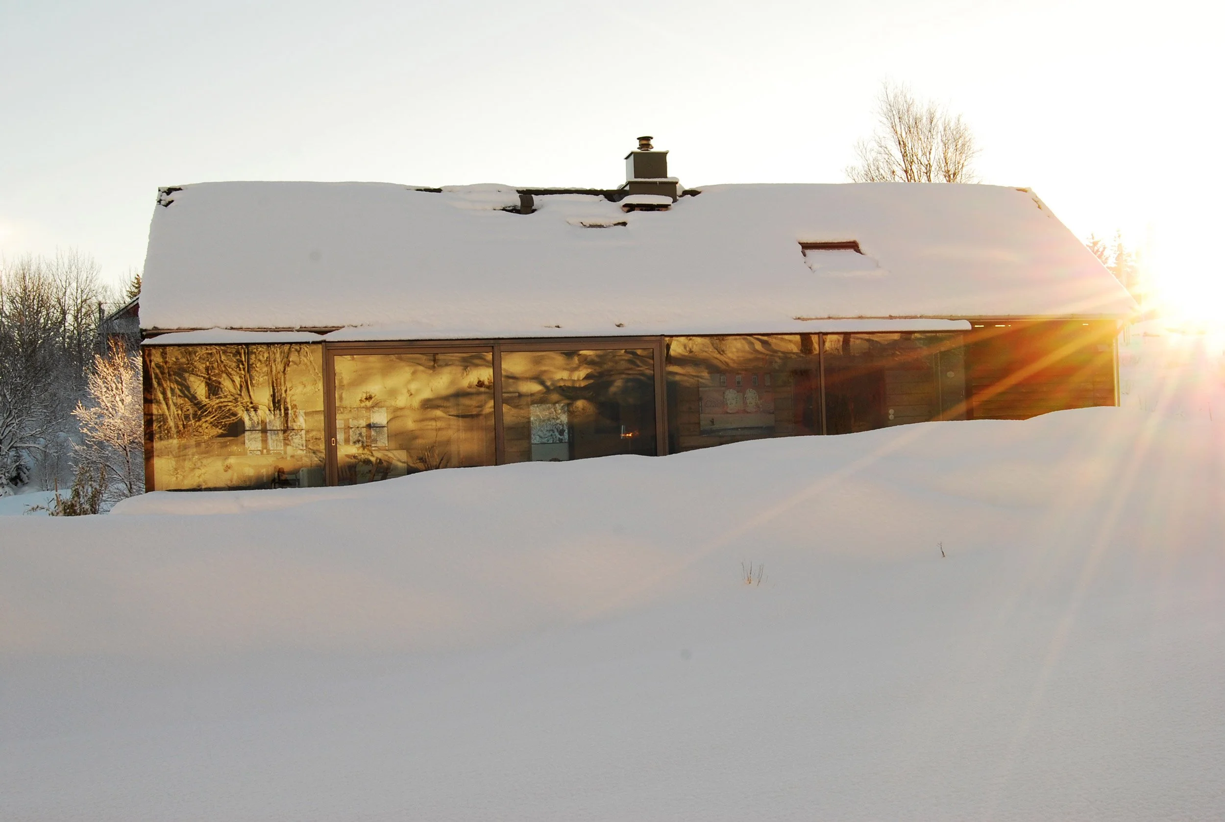 Gamlehuset med glasstilbygget som dekker hele fasaden.