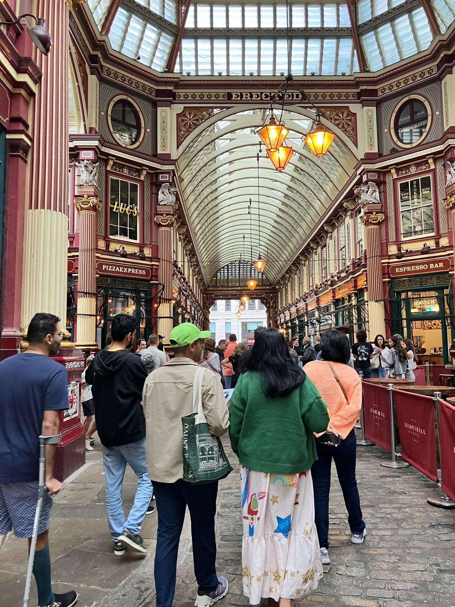 Tour group exploring Leadenhall Market exploring history of the Roman Forum and mercantilism