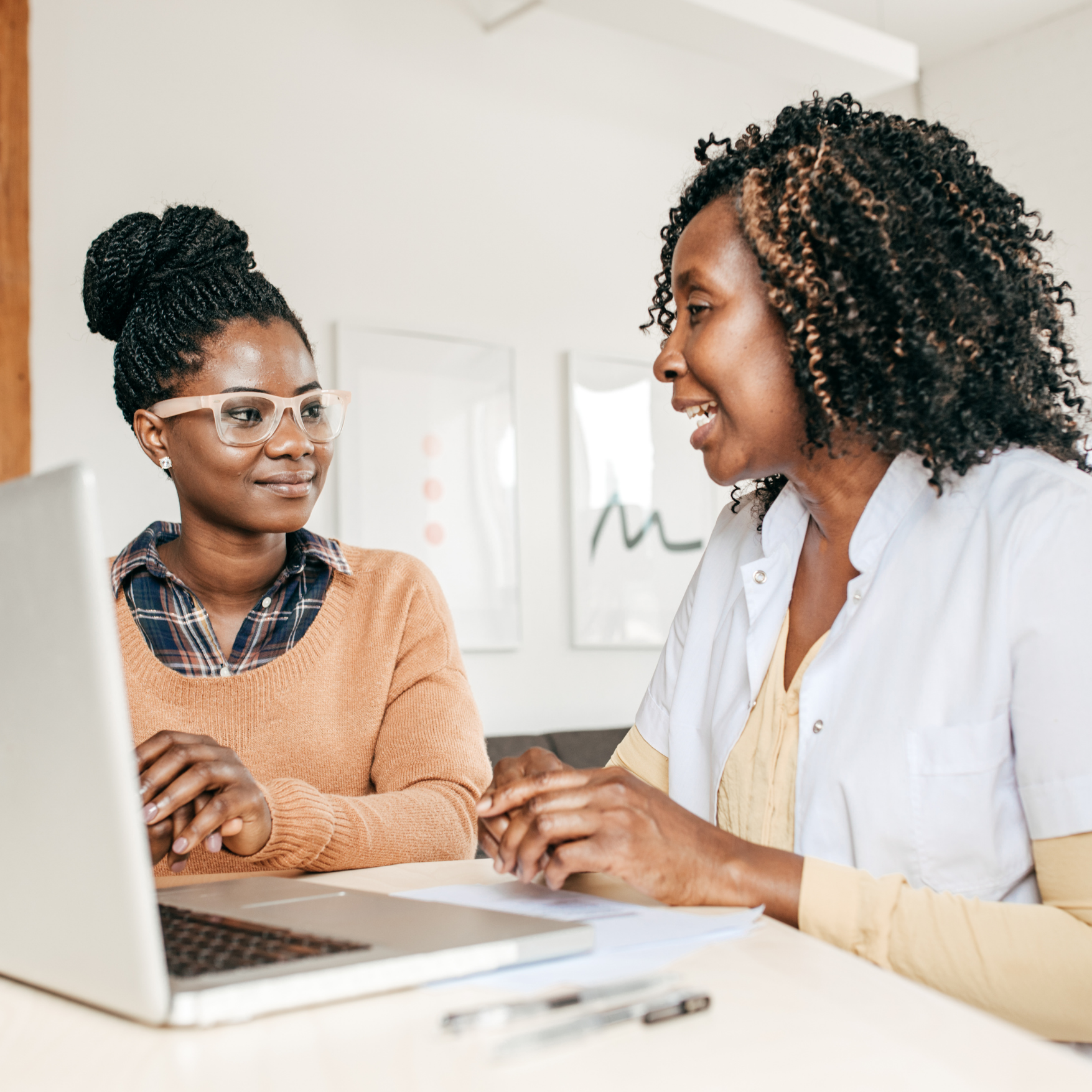 Two healthcare professionals reviewing information together at a desk, discussing compliance and regulatory guidance during a collaborative consultation.