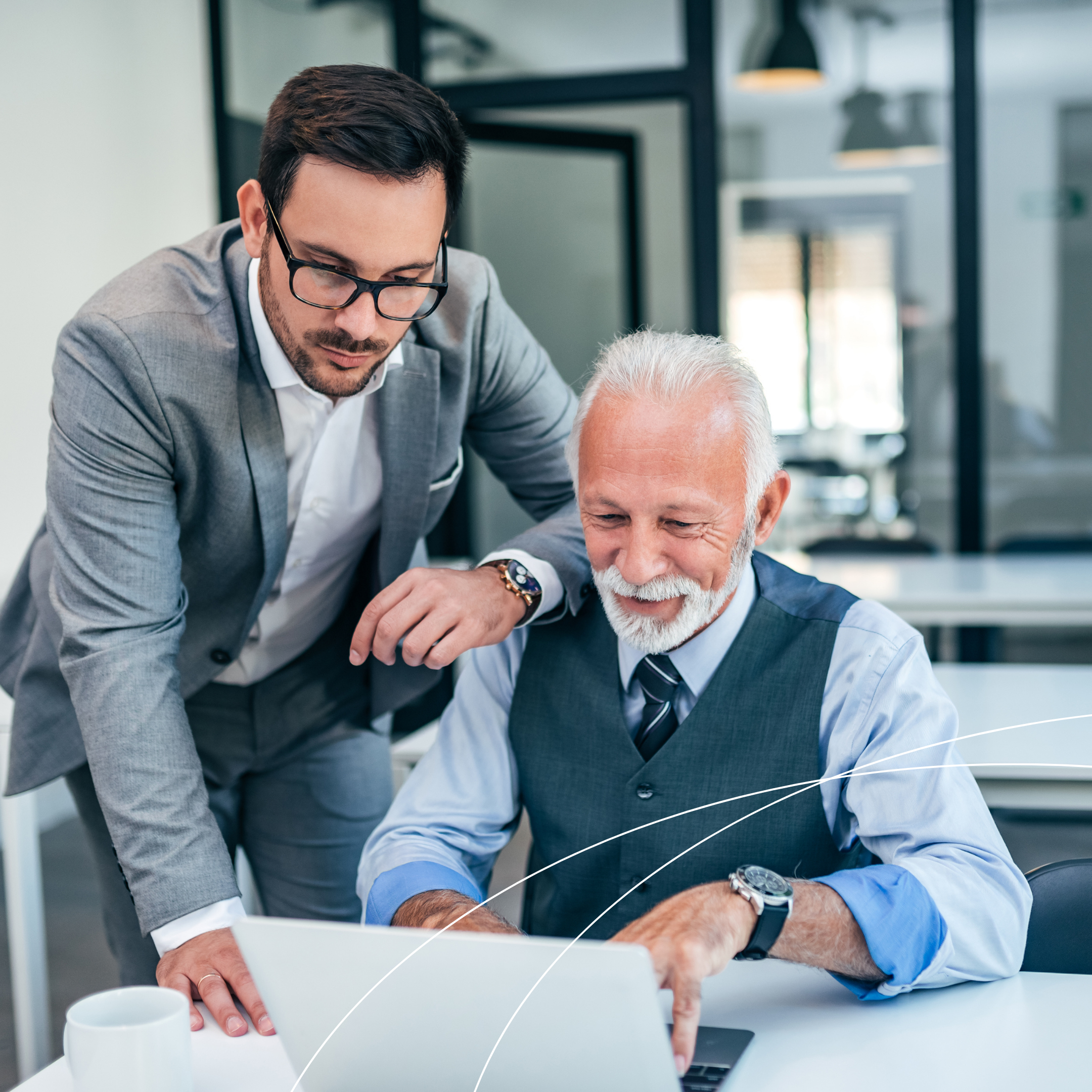 Two professionals in an office setting reviewing information on a laptop together, discussing mock survey preparation for Joint Commission