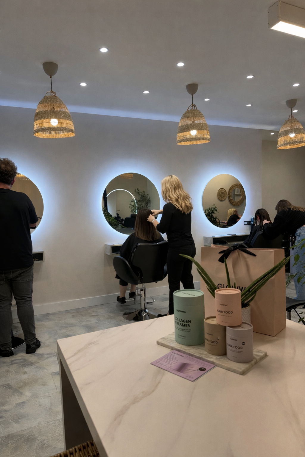 A hairstylist using a flat iron to straighten a woman's hair in a salon.