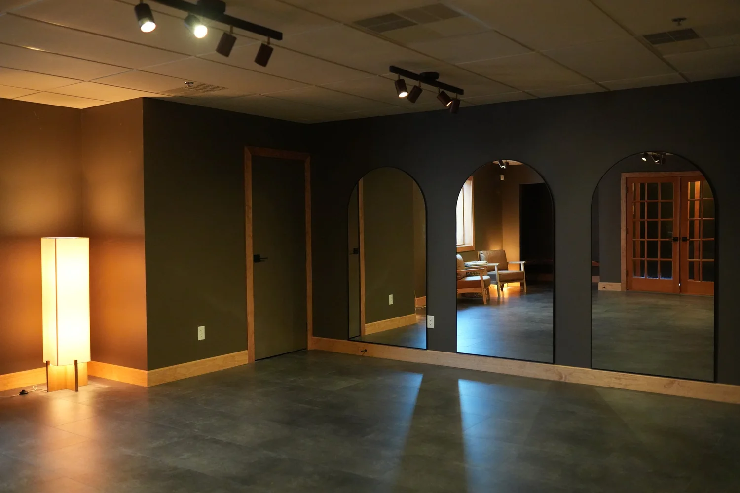 Open floor of the hothouse community studio room, looking toward the mirrored arches and french doors.