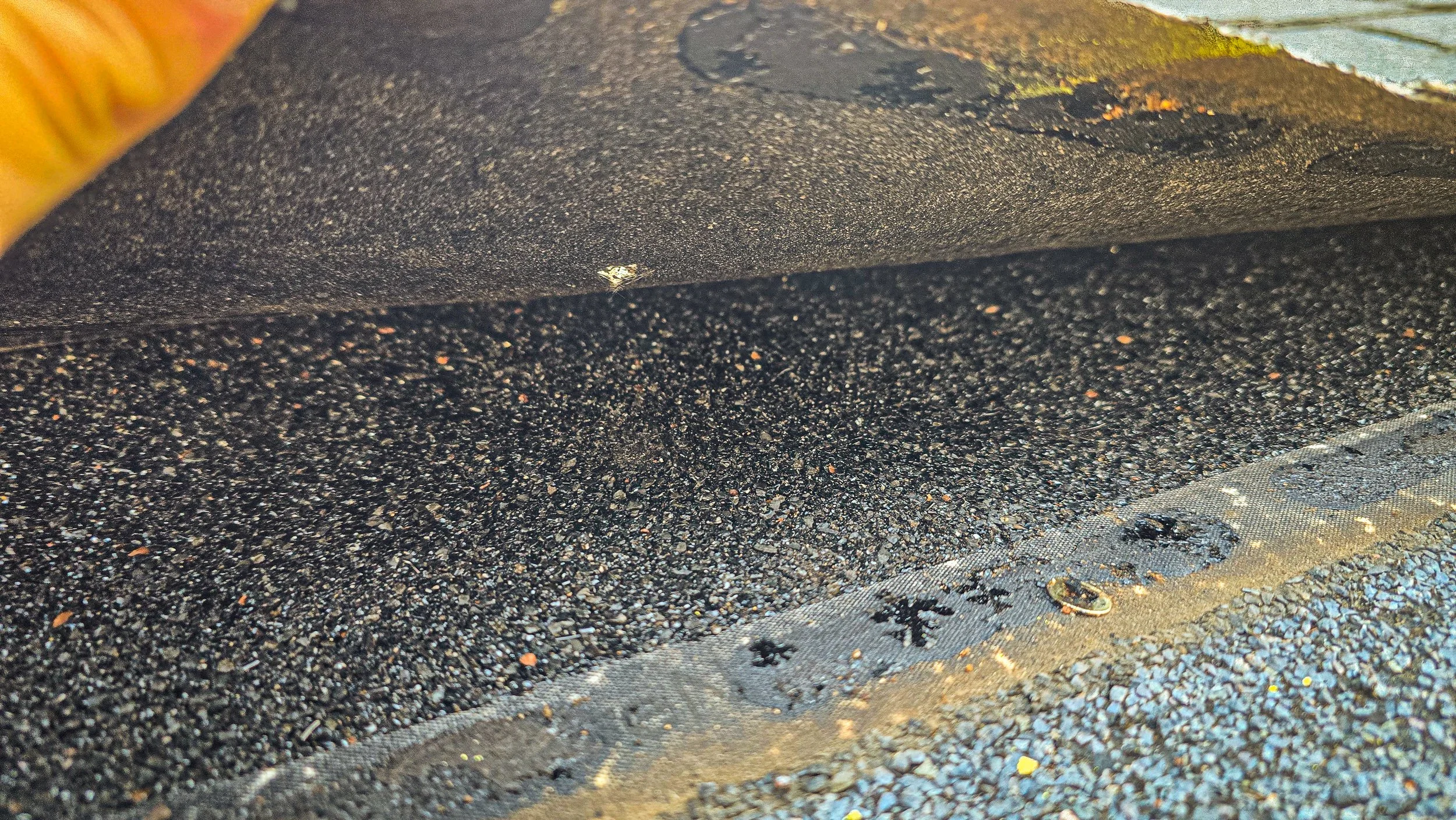 Close-up of black, textured surface with a silver metallic edge.