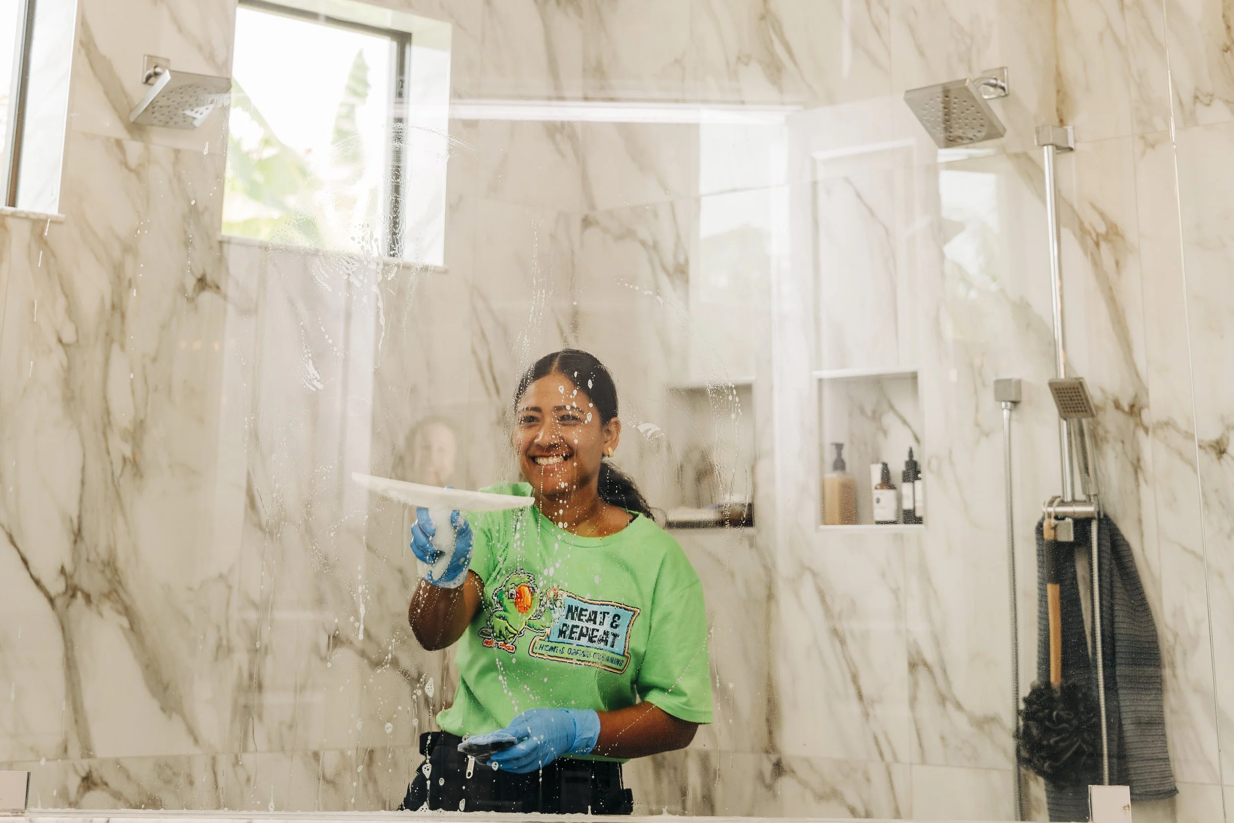 Neat and Repeat Cleaning technician cleaning a marble bathroom