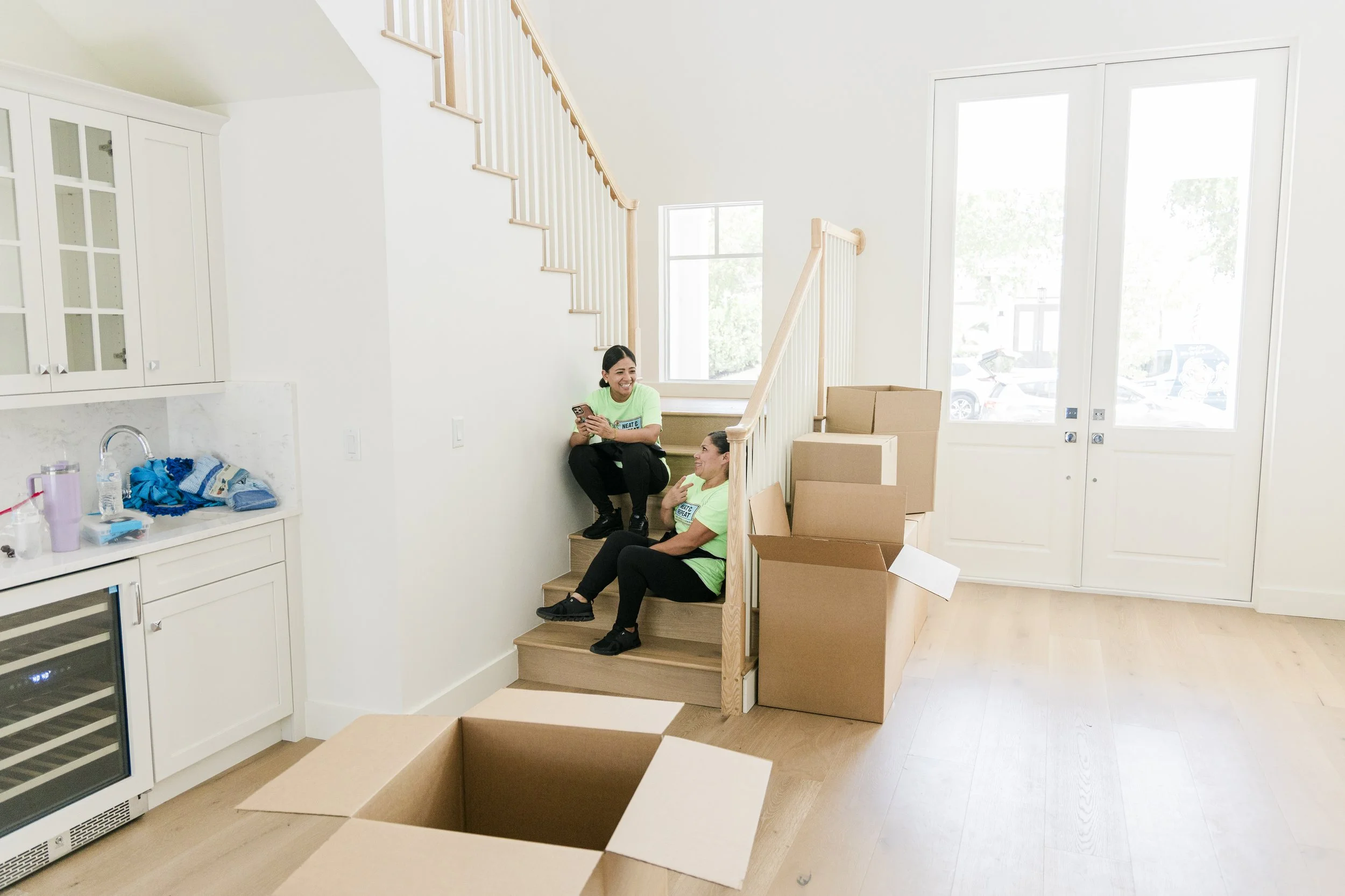 Neat and Repeat Cleaning technician cleaning a home among packed moving boxes