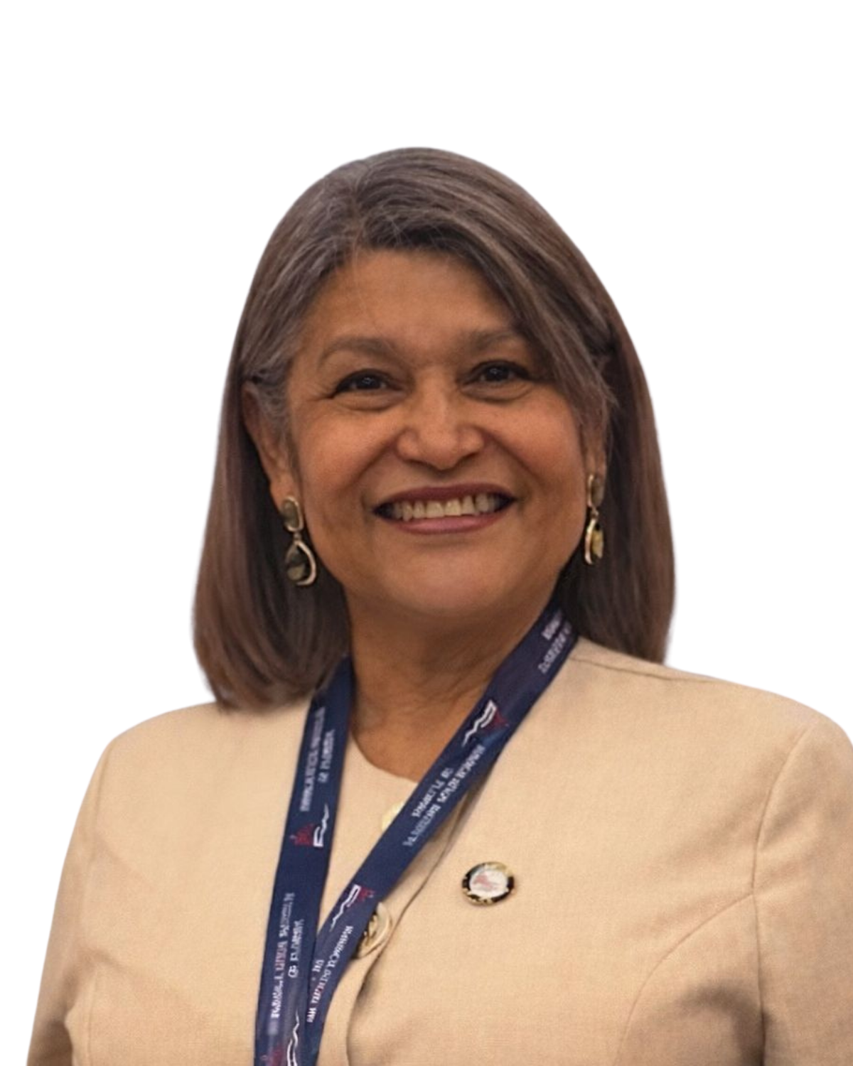 A smiling woman with shoulder-length gray hair, wearing earrings and a beige jacket with a navy blue conference lanyard and pin.
