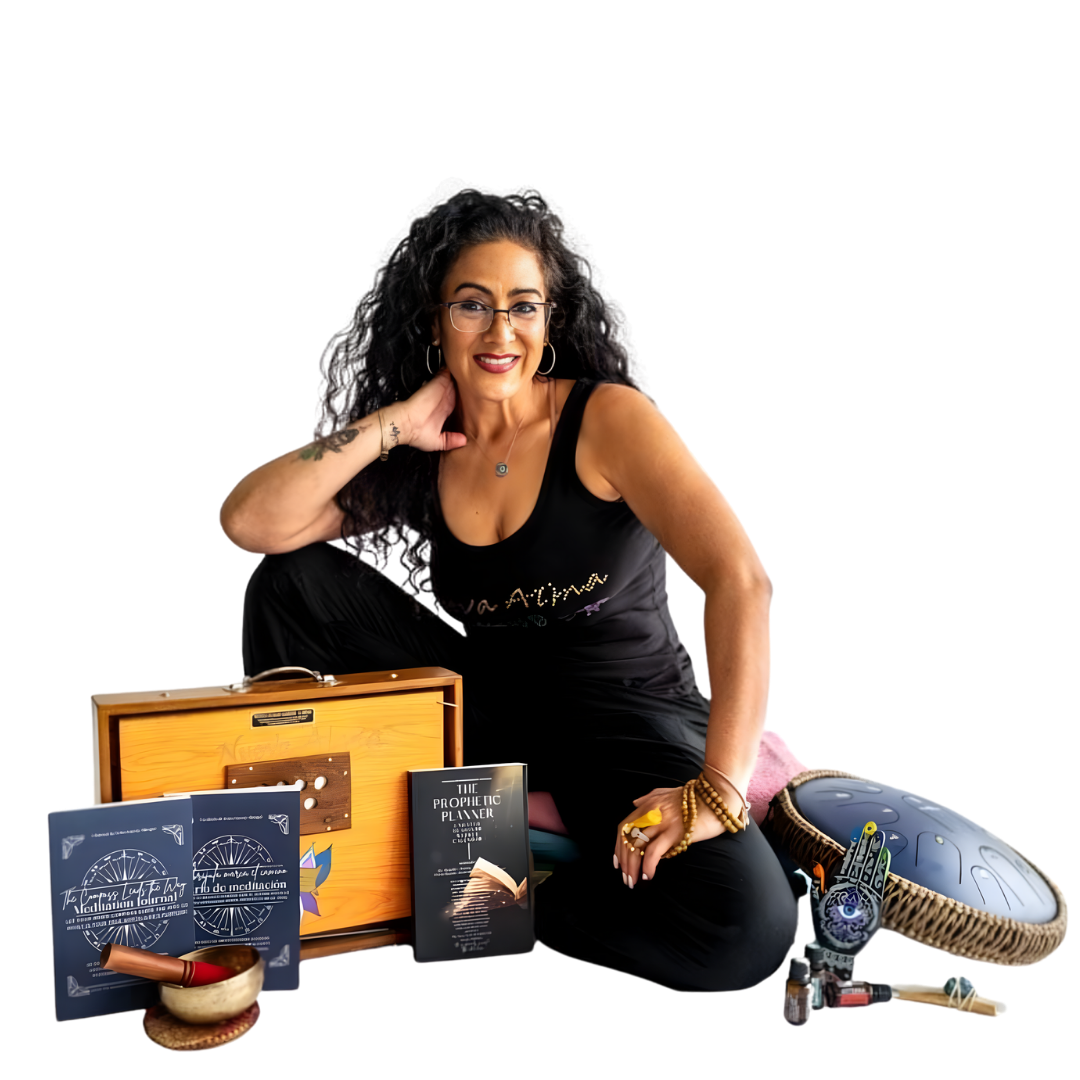 A woman with curly black hair and glasses, sitting on the floor surrounded by spiritual and musical items, smiling at the camera.