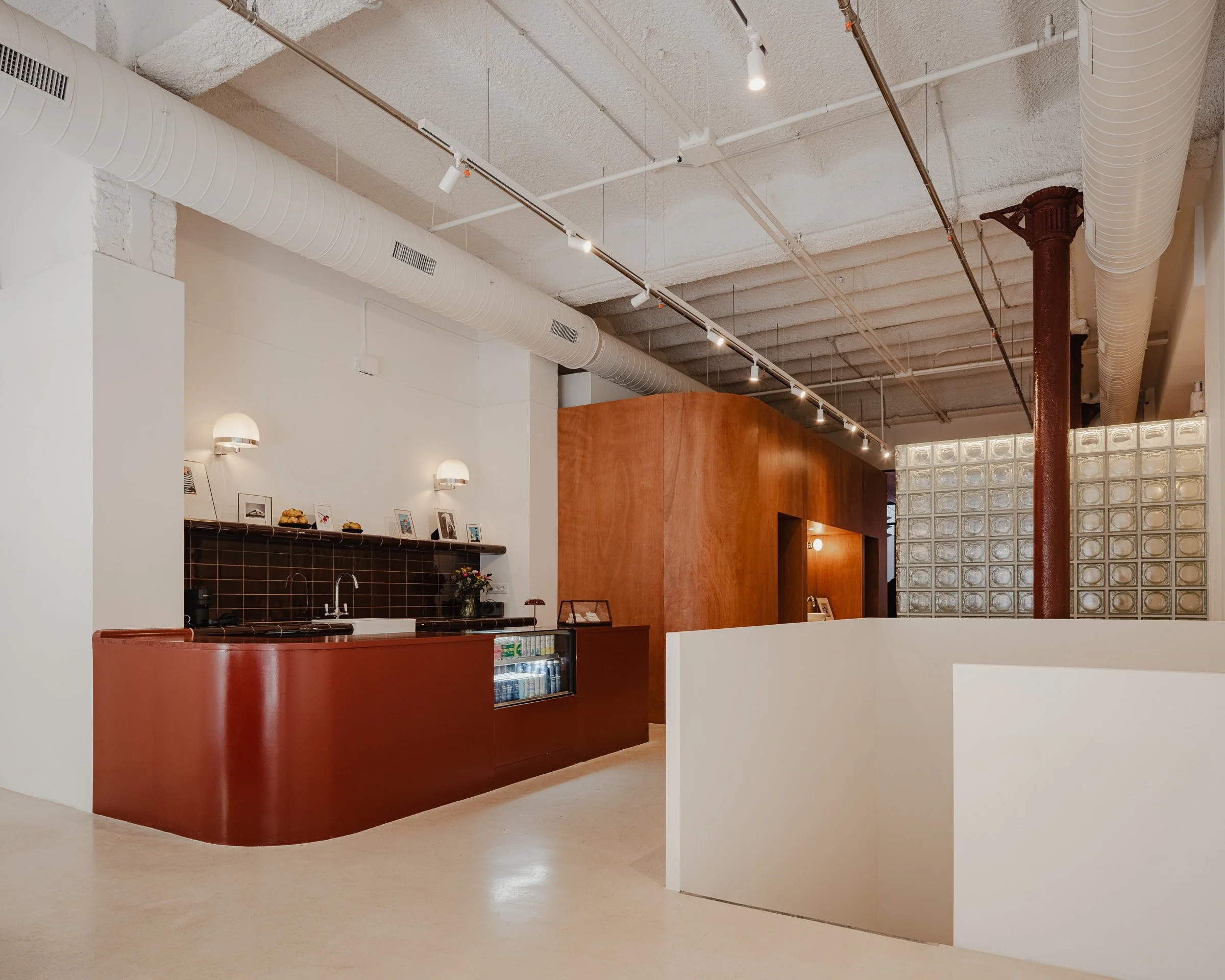Stylish red bar with wood paneled wall behind it and a glass block to its opposite.