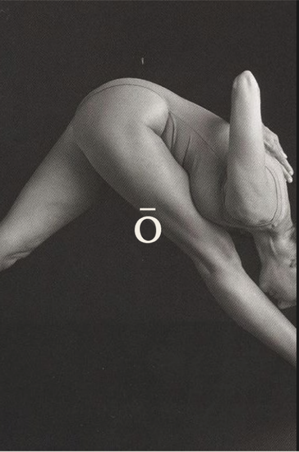 Black and white photo of a person's hand making a gesture resembling a finger pointing upward, with an overline symbol and the letter 'O' in the center.